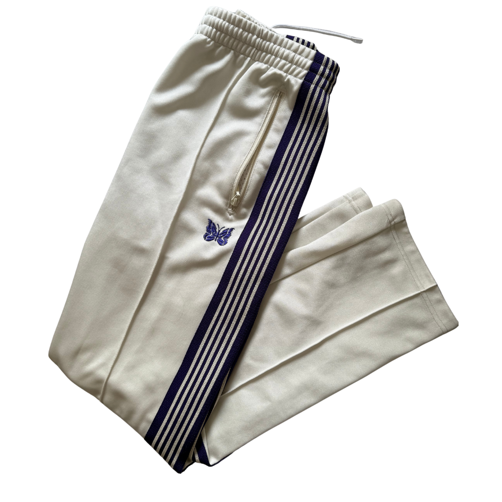 Needles Track Pants White and Purple, featuring striped taping and embroidered butterfly logo with zippered pockets.