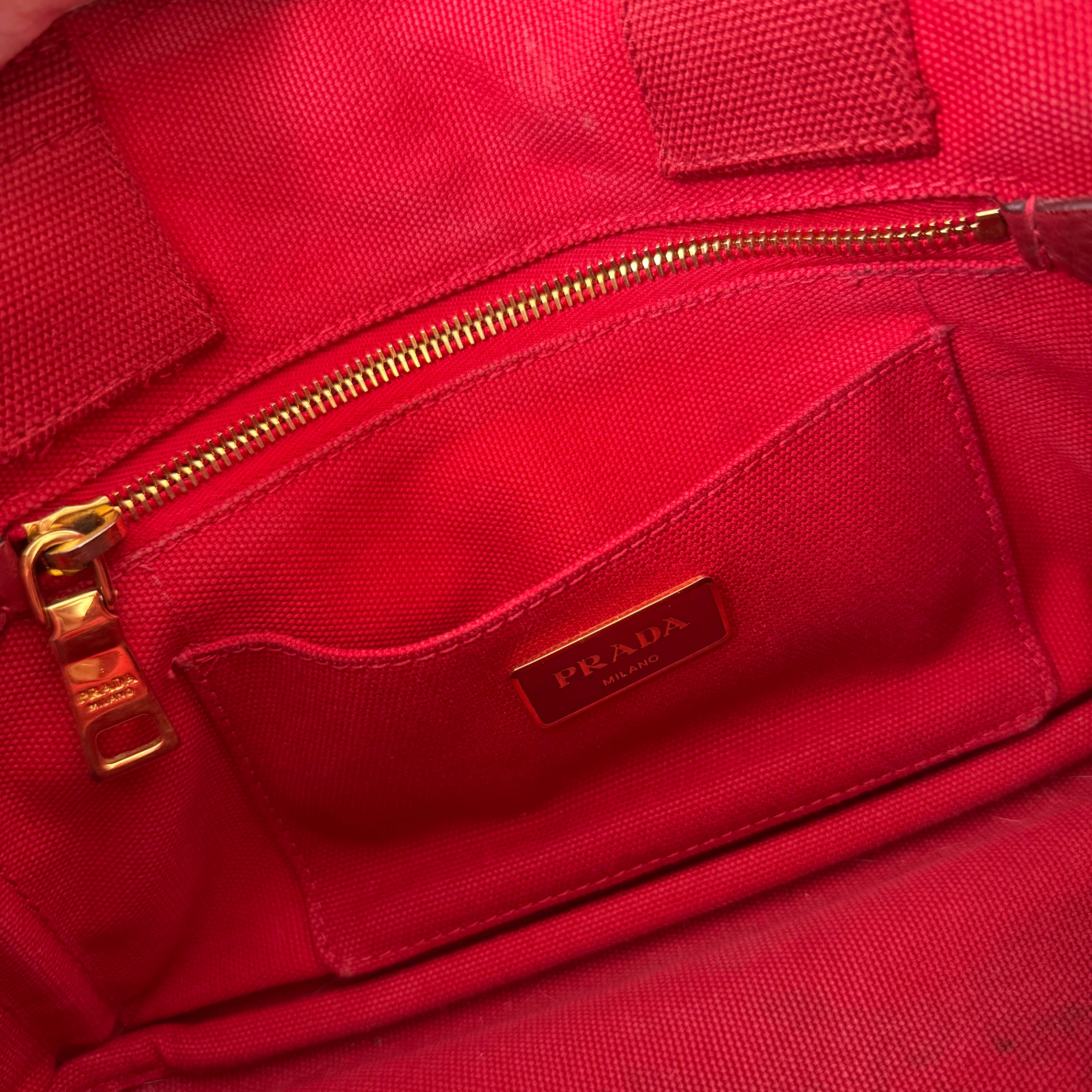 Prada Canapa Tote Bag in red canvas with black logo embroidery, featuring a structured silhouette and dual top handles for effortless style.