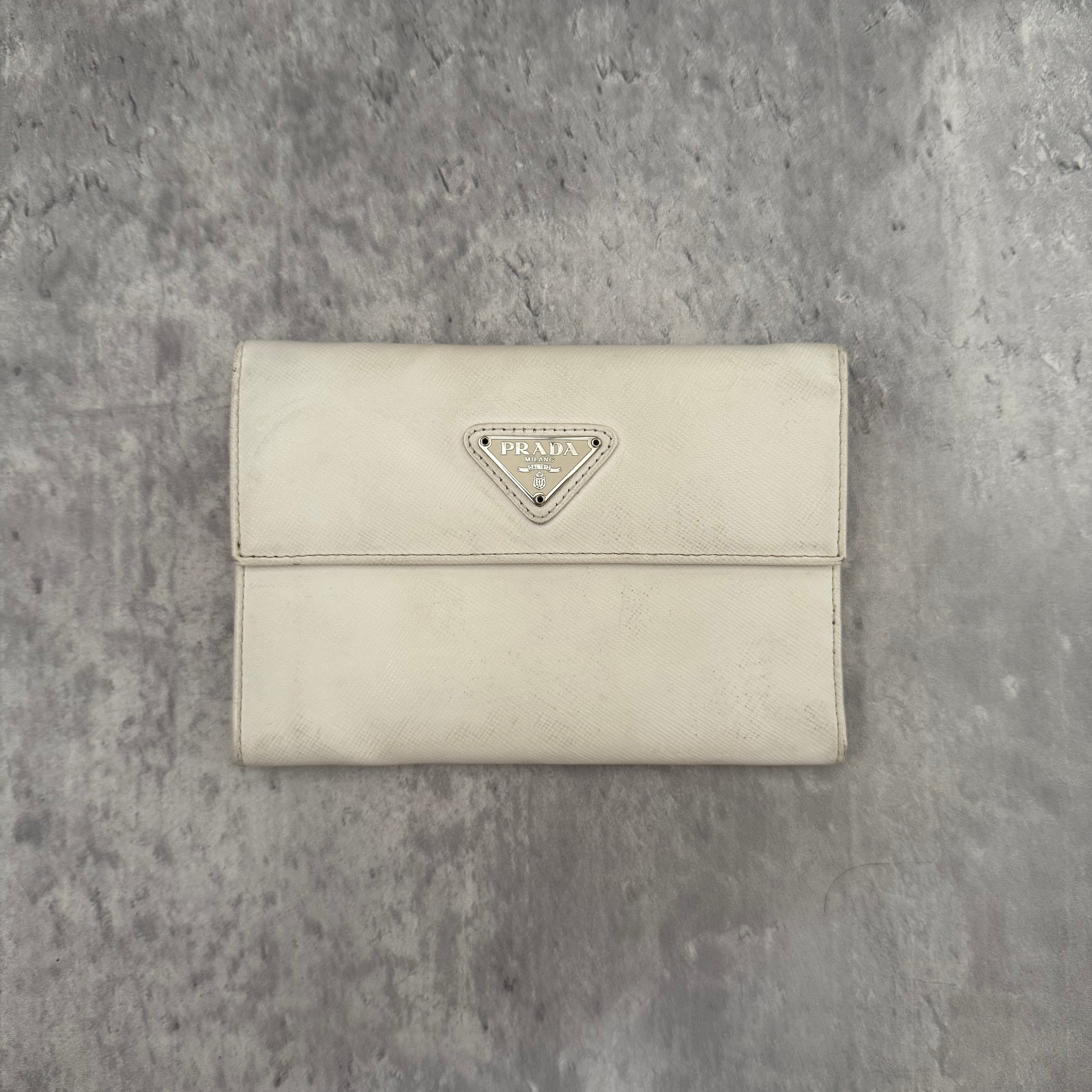 Pre-loved Prada Tessuto Nero leather trifold wallet with triangle logo plate in off-white, featuring card slots and a snap closure.