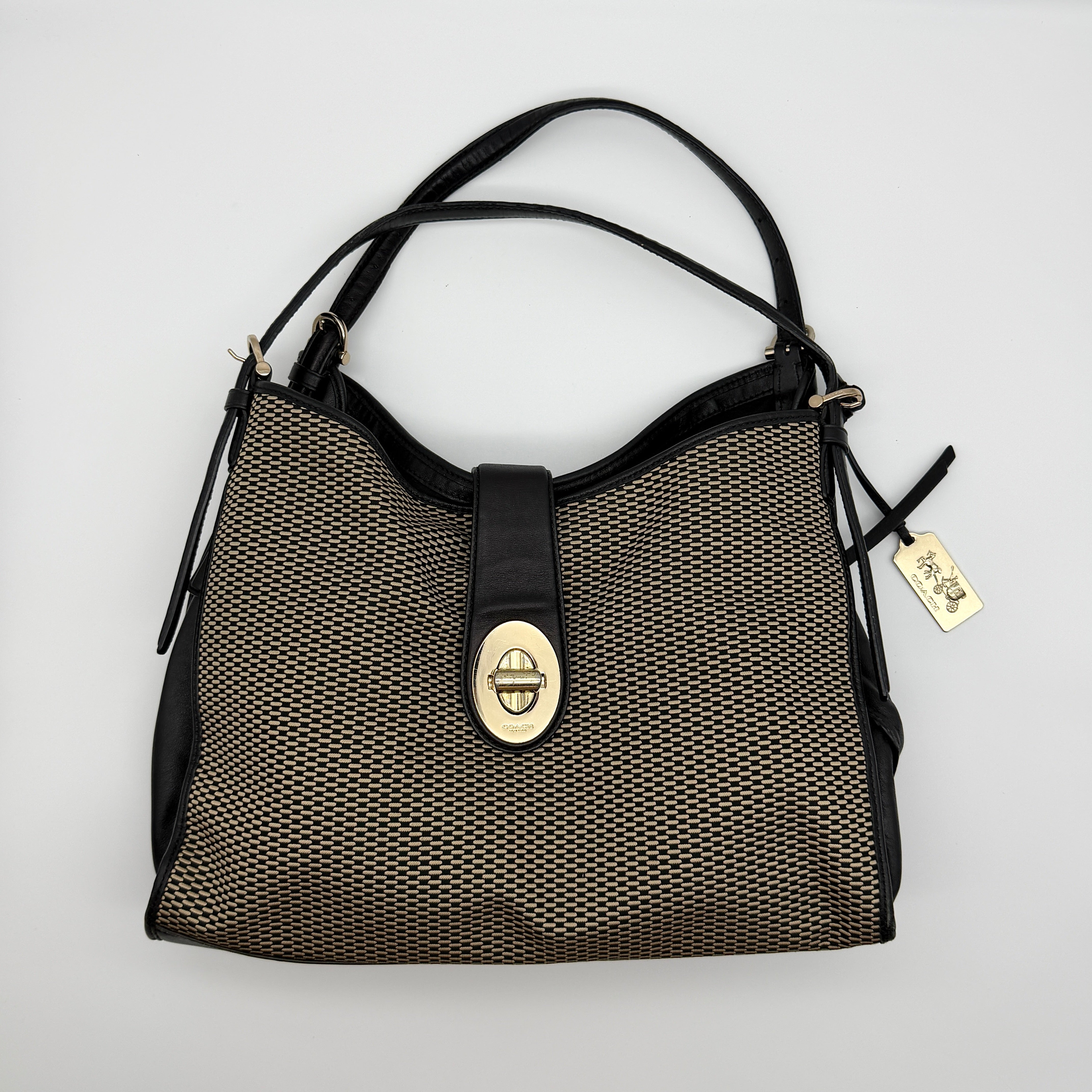 Coach Madison Carlyle Shoulder Bag with woven black and beige body, black leather trim, and gold turnlock closure