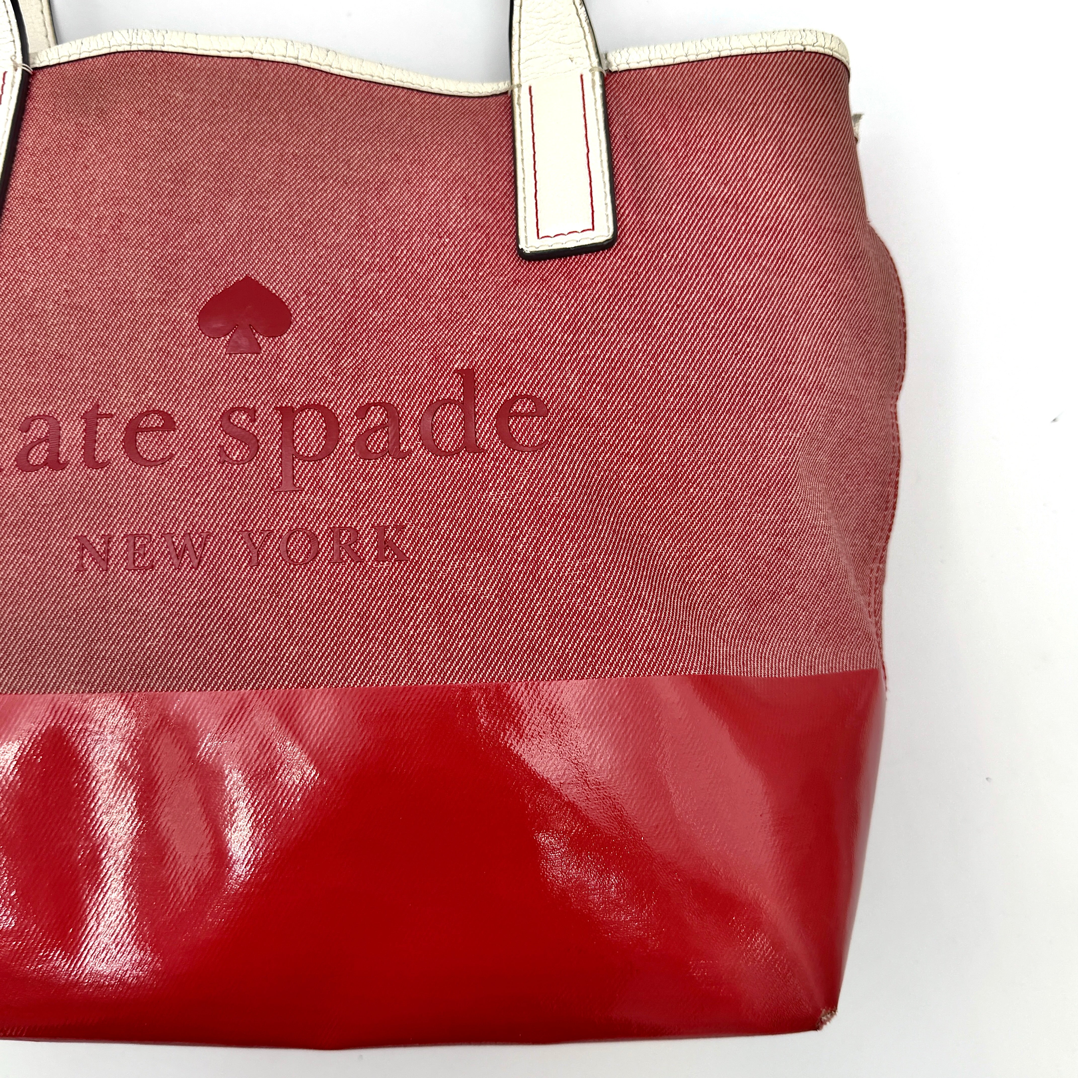 Kate Spade Ash Street Logo Tote in red canvas with glossy red leather base and ivory handles, shown against a white background.