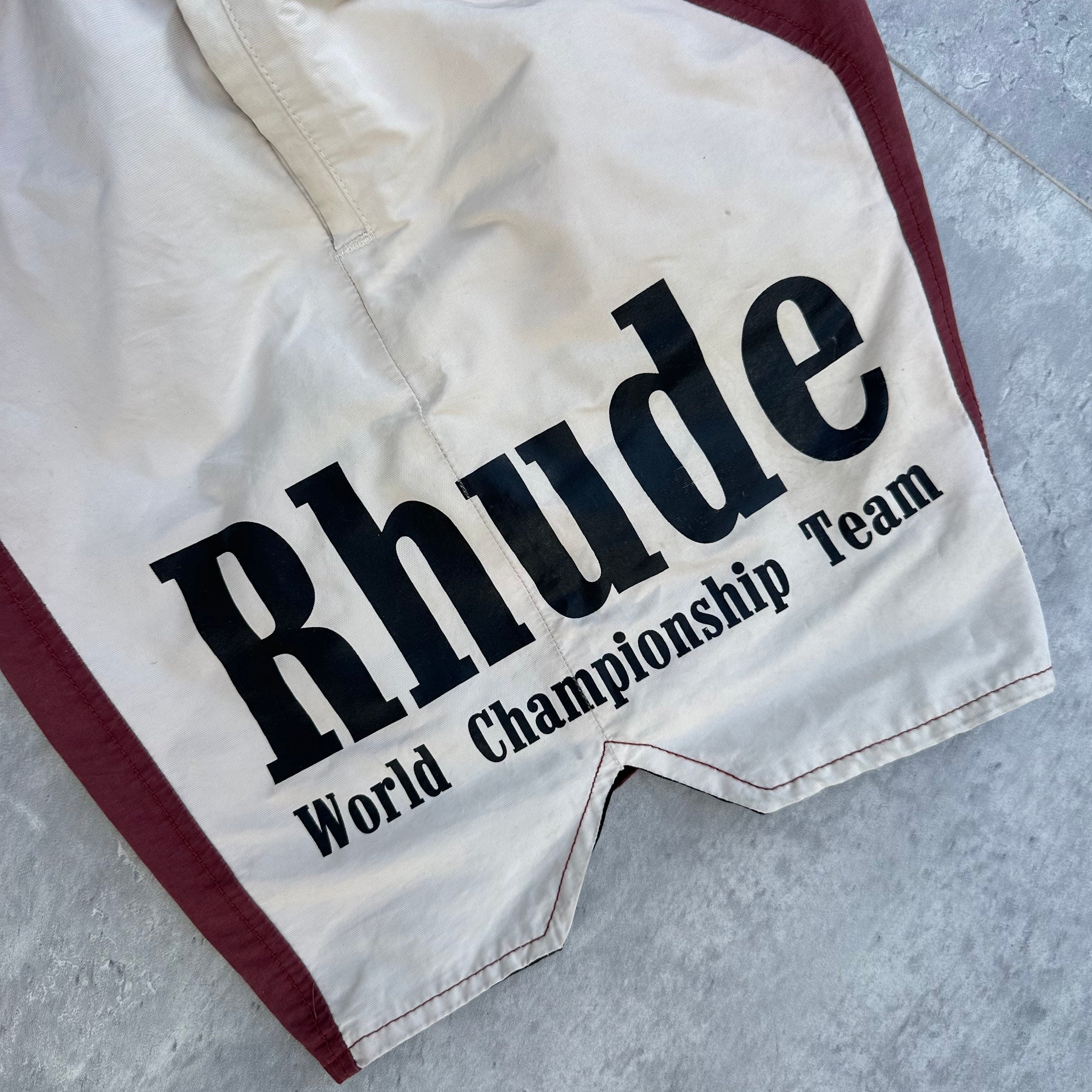 Rhude Panel Logo Shorts Maroon/White/Multi FW22, featuring championship print and moon graphic, with yellow drawstring and bold panel design.