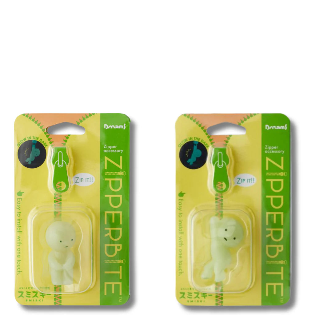Smiski ZipperBite accessories glowing in the dark and clipped onto zippers, featuring soft vinyl Smiski figures in playful poses