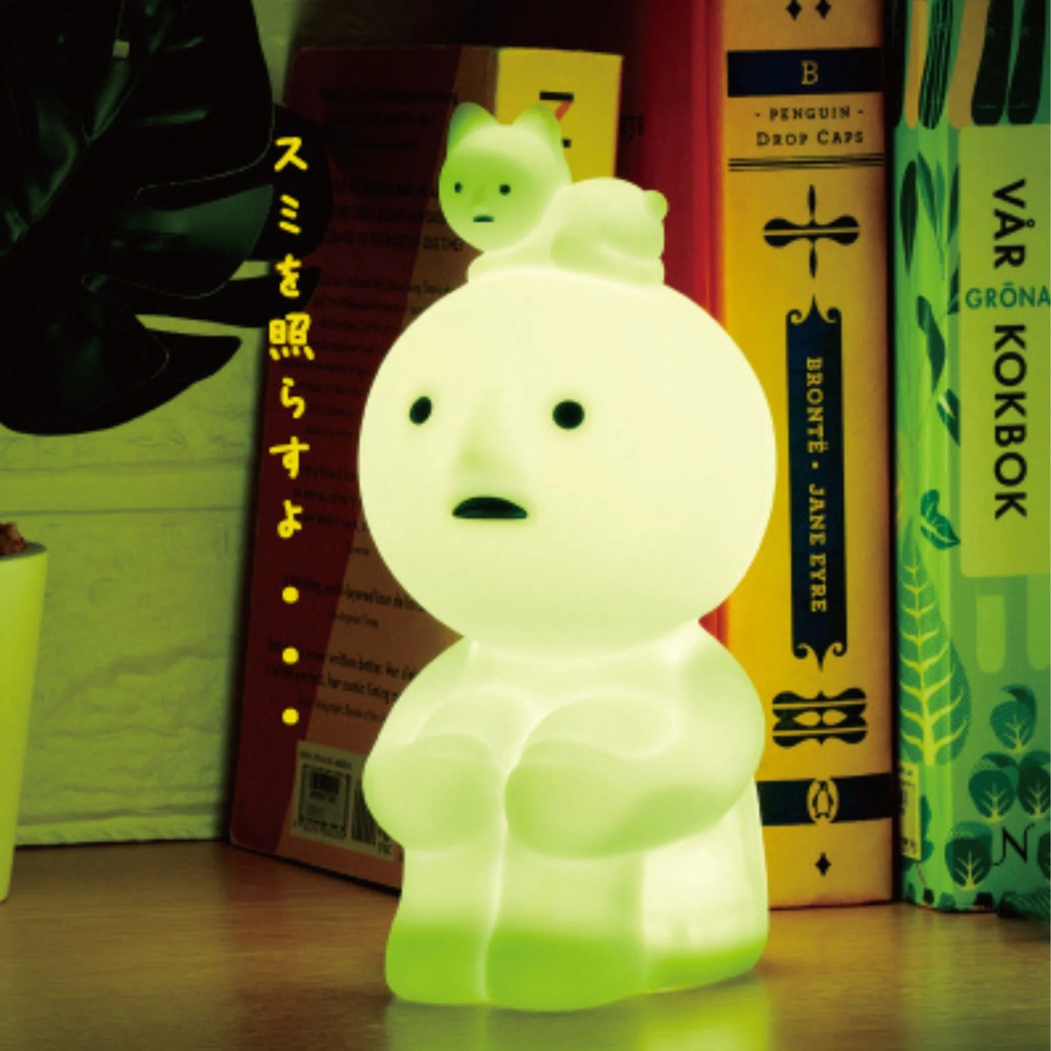 Smiski Touch Light glowing softly on a desk, featuring a seated Smiski figure with a cat character on its head