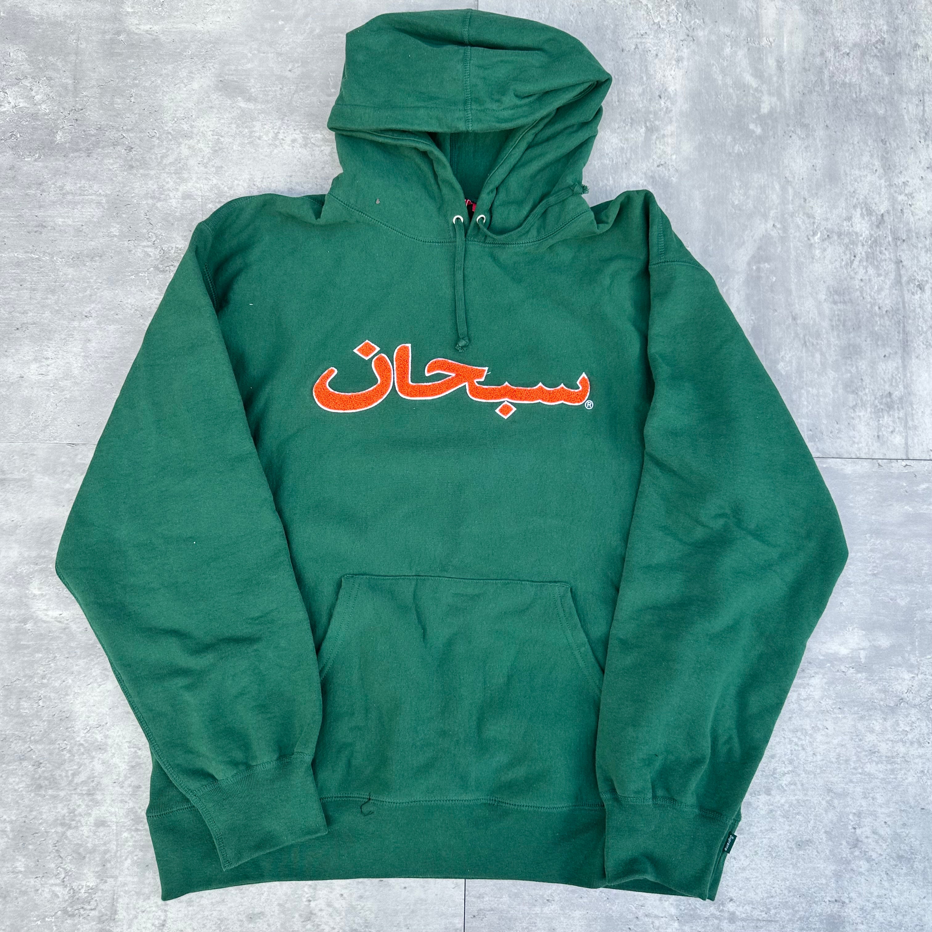 Supreme Arabic Logo Hoodie FW21 in green, featuring orange Arabic logo embroidery and kangaroo pocket, made from heavyweight cotton.
