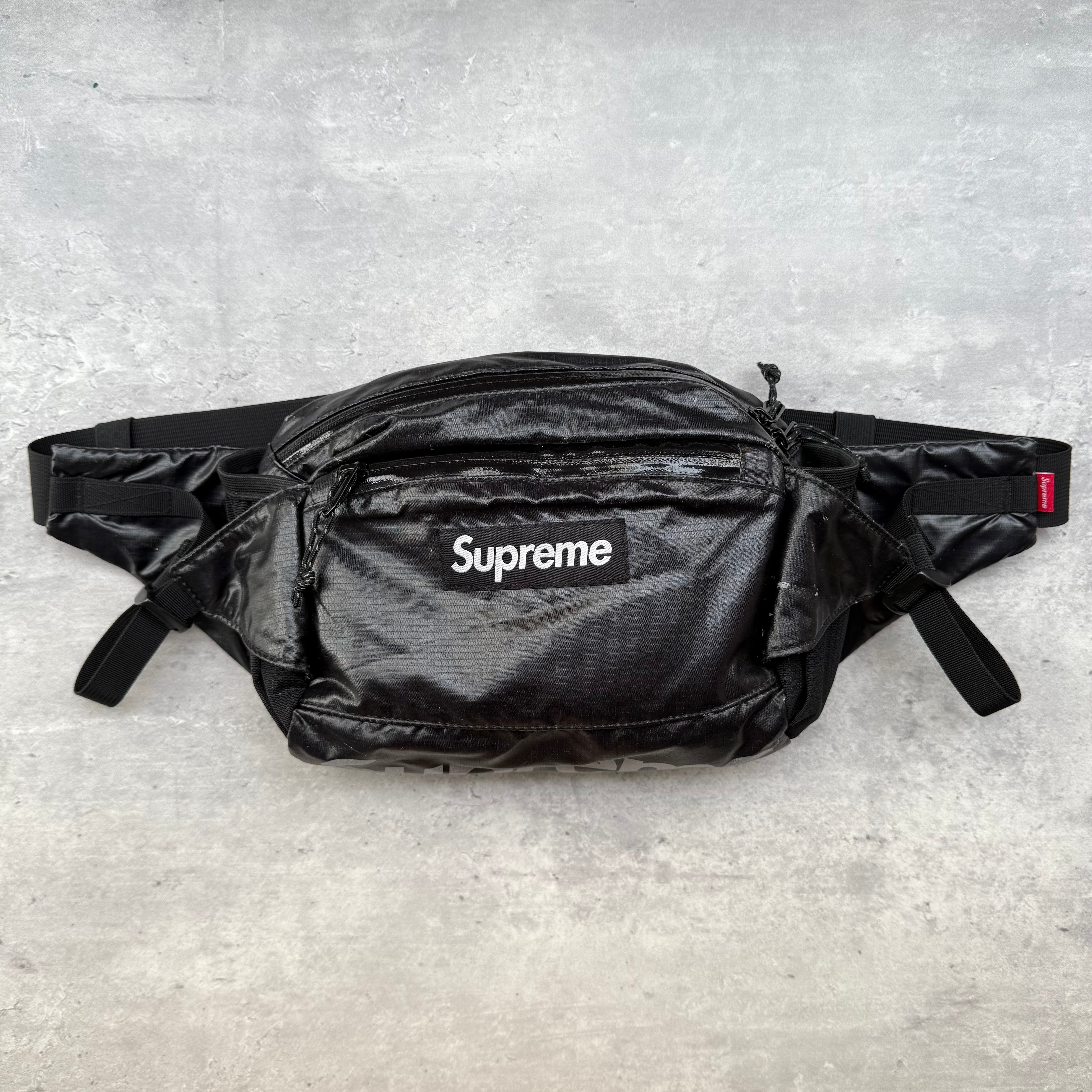 Supreme Waist Bag Black, crafted from ripstop nylon with front box logo and reflective Supreme branding, adjustable strap and multiple compartments.