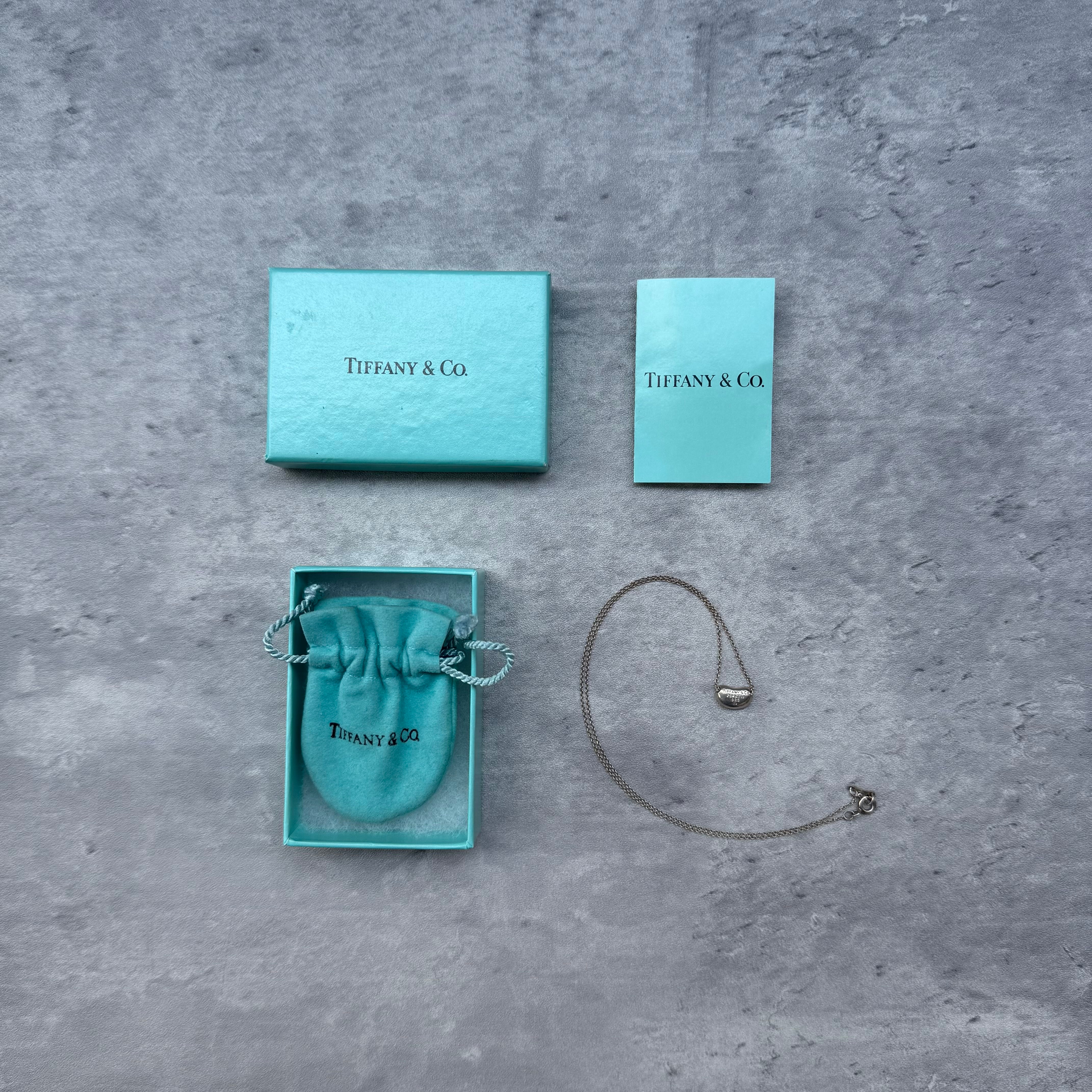 Tiffany & Co. Mini Elsa Peretti Bean Pendant Necklace in sterling silver with original box and pouch.