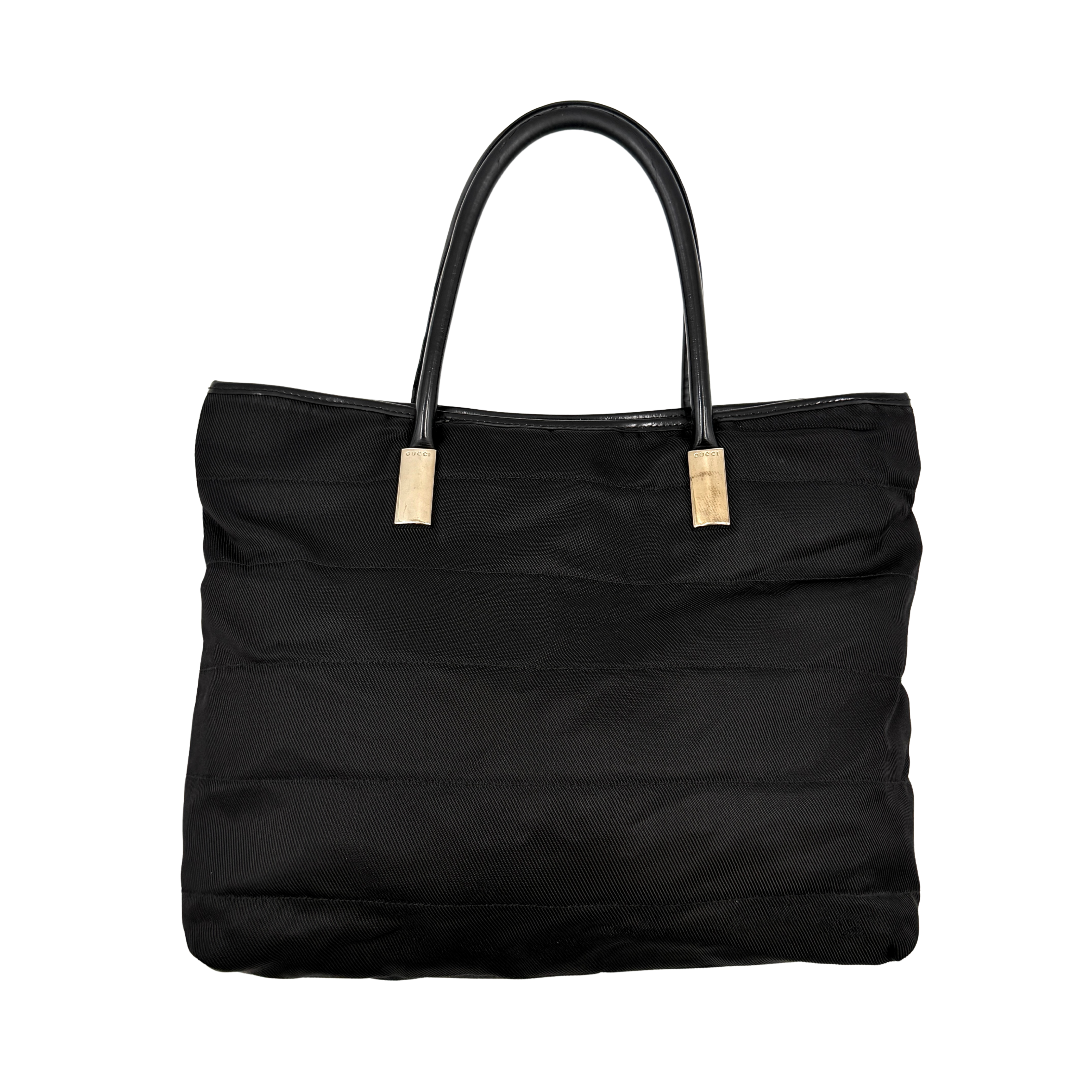 A classic black Gucci nylon tote bag with leather handles and gold-tone hardware displayed upright against a clean background.