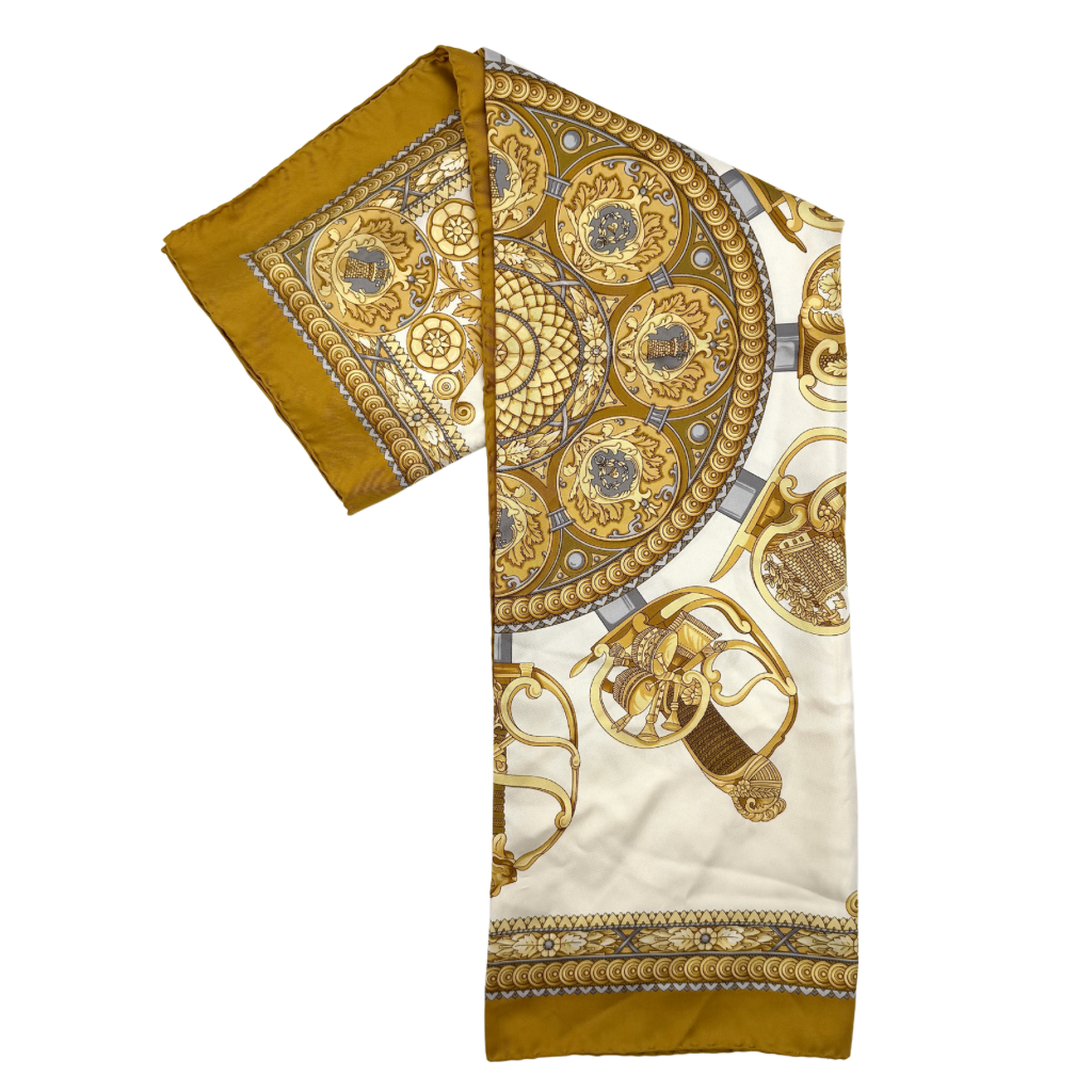 Gucci silk scarf in gold and white, featuring an intricate equestrian medallion design with ornate sabres and classical borders.