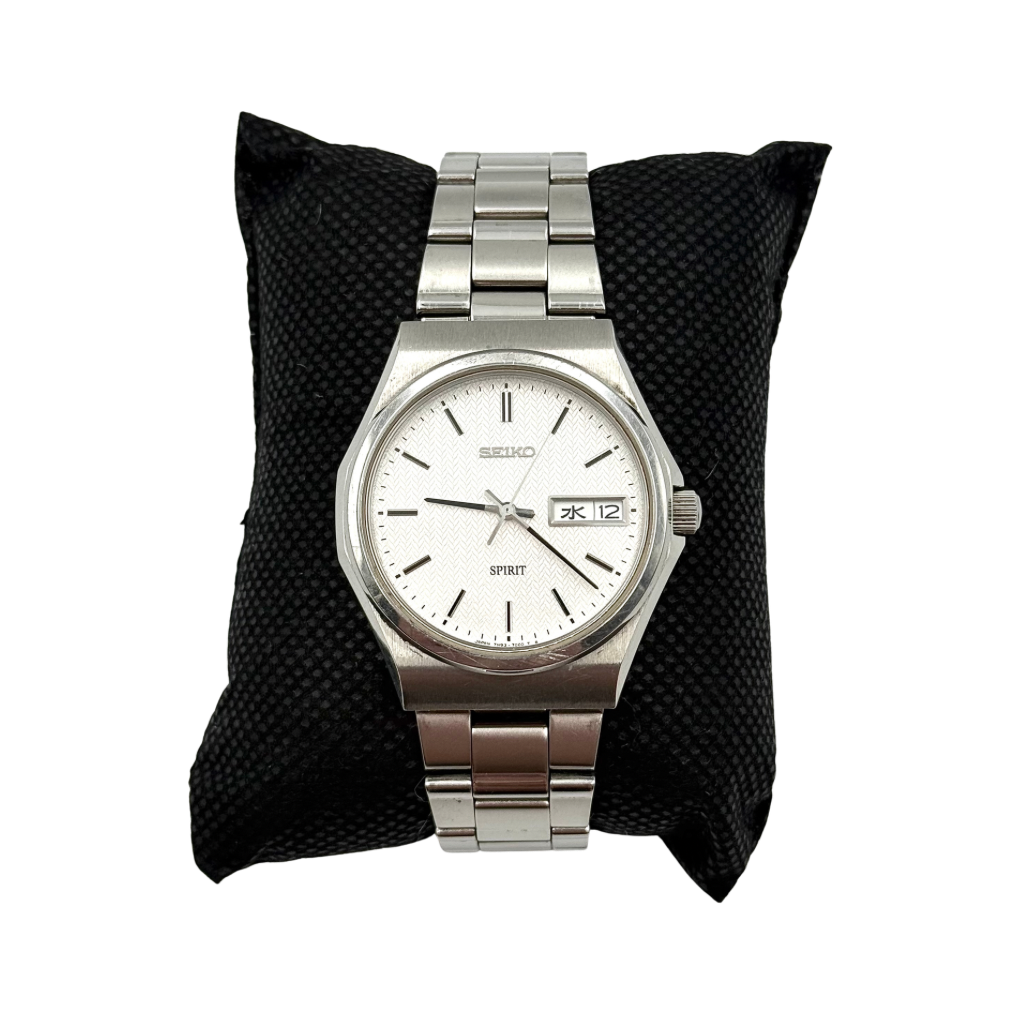 Seiko Spirit 7N93-7000 Quartz Watch in silver with a white textured dial and stainless steel bracelet, shown on a black cushion.