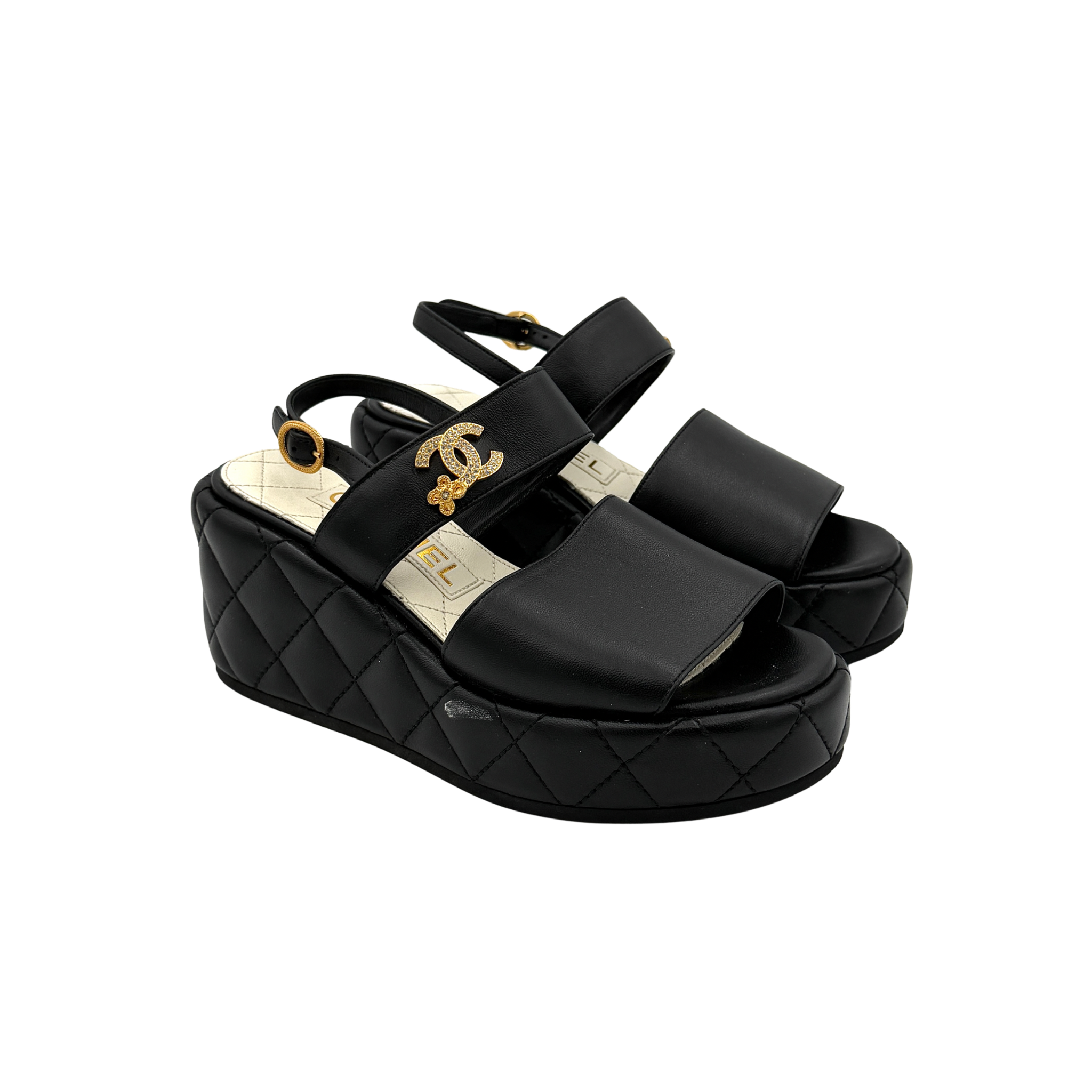 Chanel black quilted leather wedge platform sandals with gold crystal CC hardware and ankle strap detailing.