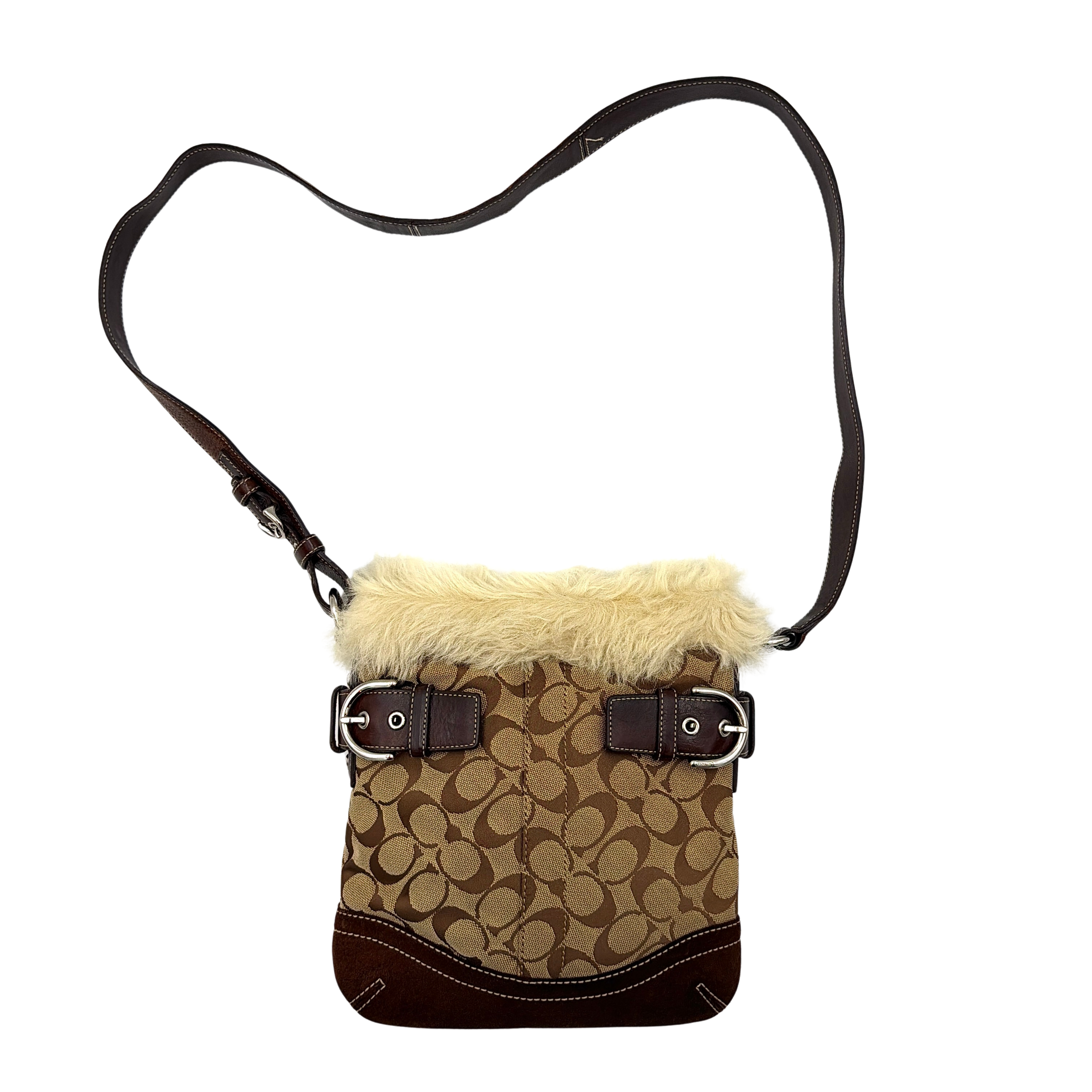 Coach Signature canvas crossbody bag in brown and beige with cream faux fur trim and leather buckle accents, shown with adjustable strap.