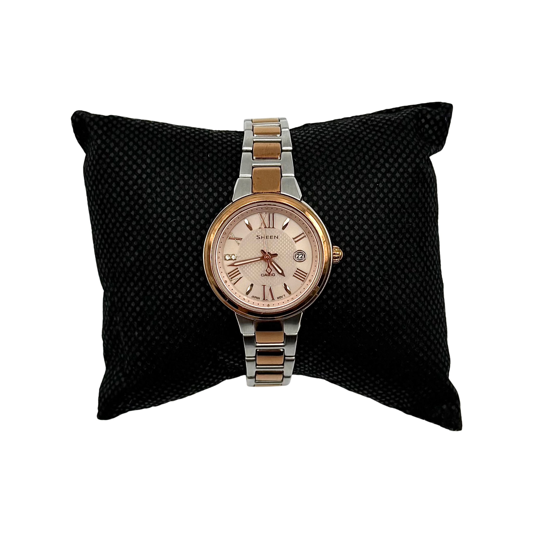 Casio Sheen SHE-4516 stainless steel watch with a rose gold and silver bracelet displayed on a black cushion.