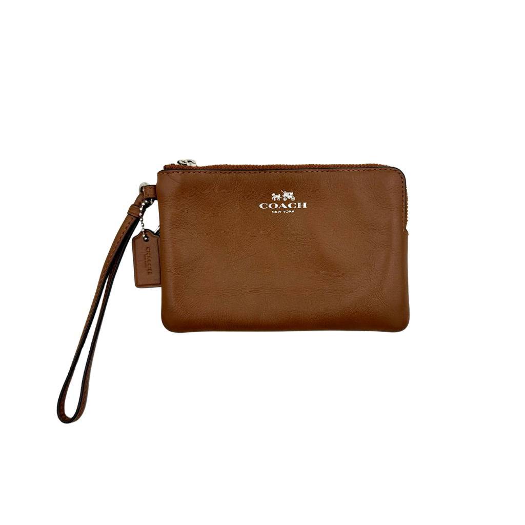 Coach Corner Zip Wristlet in smooth brown leather with silver logo and detachable wrist strap shown against a clean background.