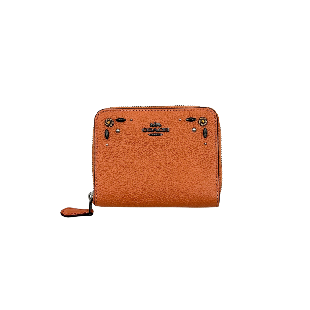 Coach Prairie Rivets Zip Around Small Wallet in orange pebbled leather with floral rivets and zip-around closure.