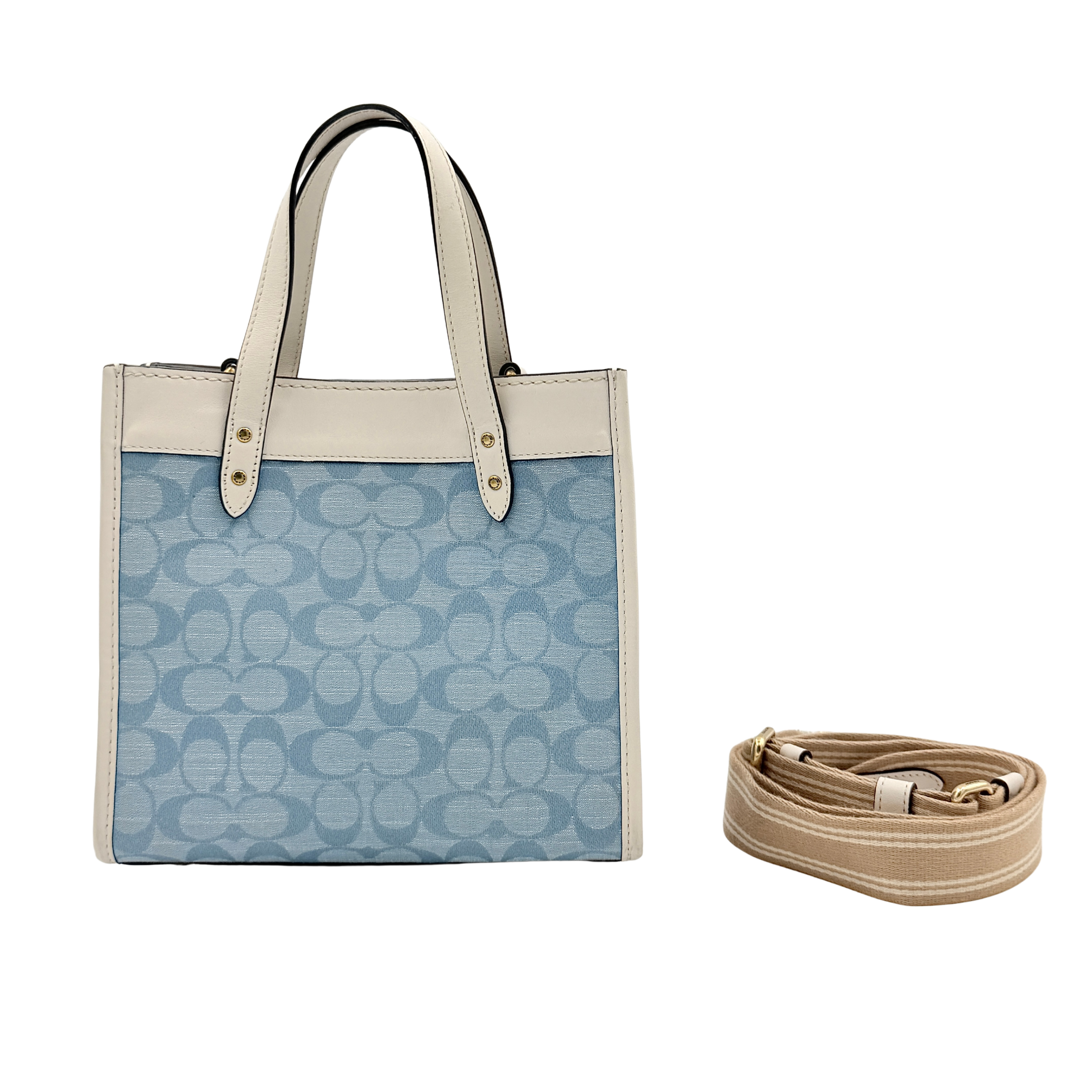 Coach Field Tote 22 in blue signature jacquard with white leather trim and detachable strap, styled for versatile wear.