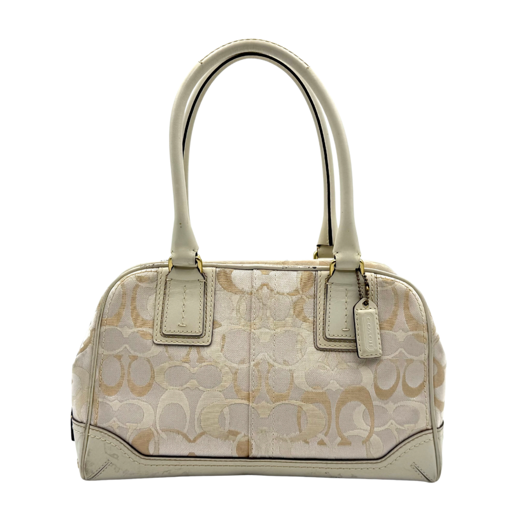 Coach Signature Canvas Satchel in ivory with dual rolled handles, monogram pattern and leather trim shown from the front against a clean background.