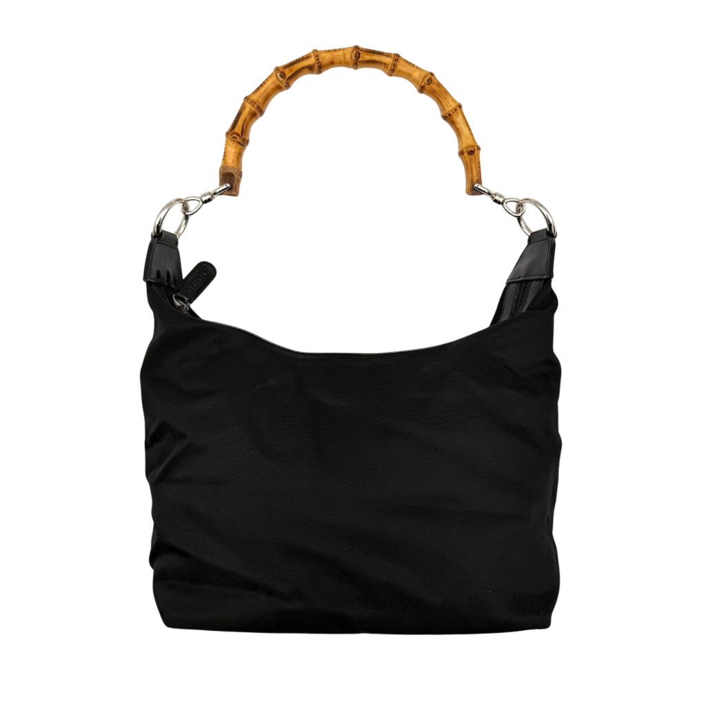 Gucci black nylon shoulder bag with a sculpted bamboo top handle and sleek silhouette against a white background.