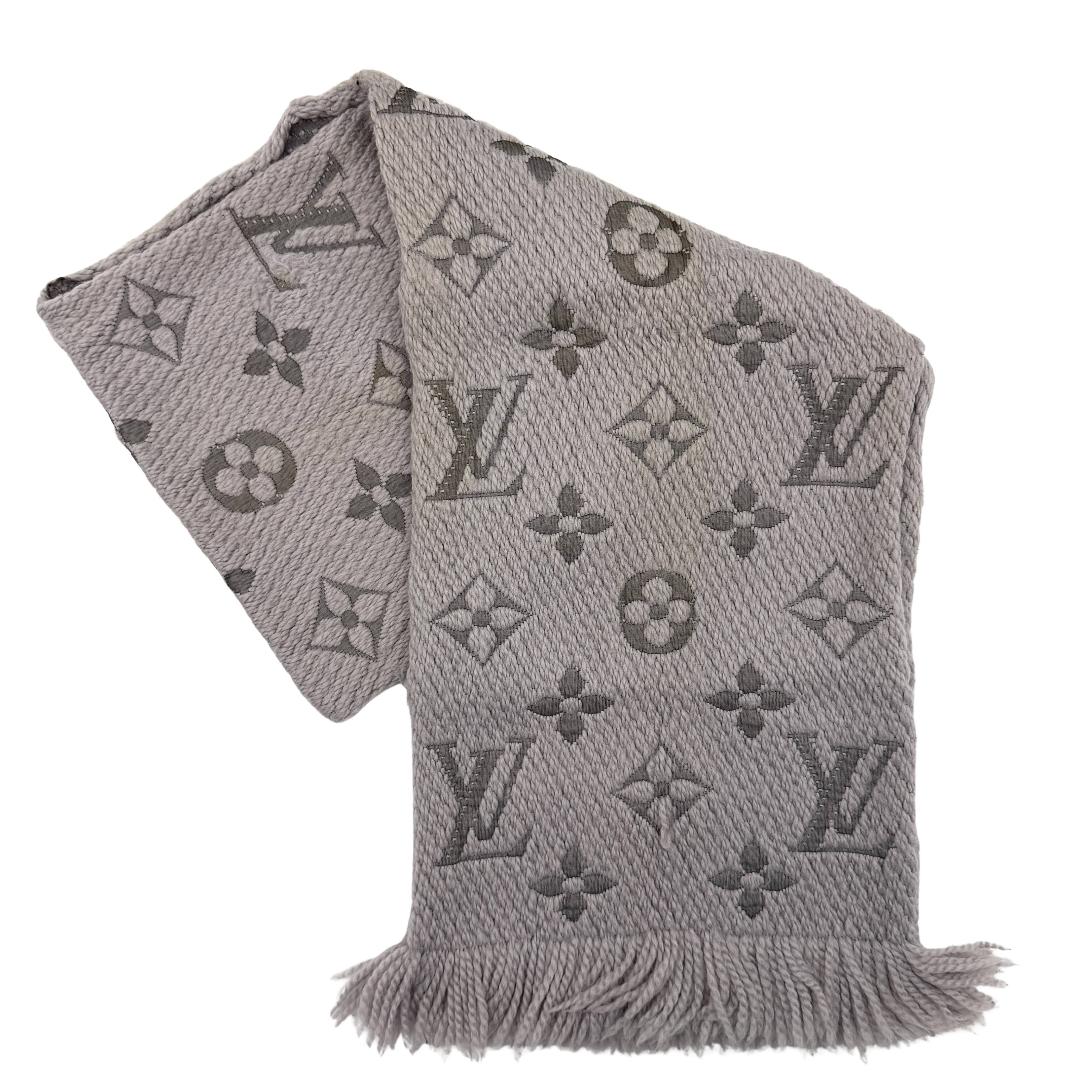 Louis Vuitton grey wool scarf featuring an all-over monogram pattern with soft fringed edges, elegantly draped for a premium look.