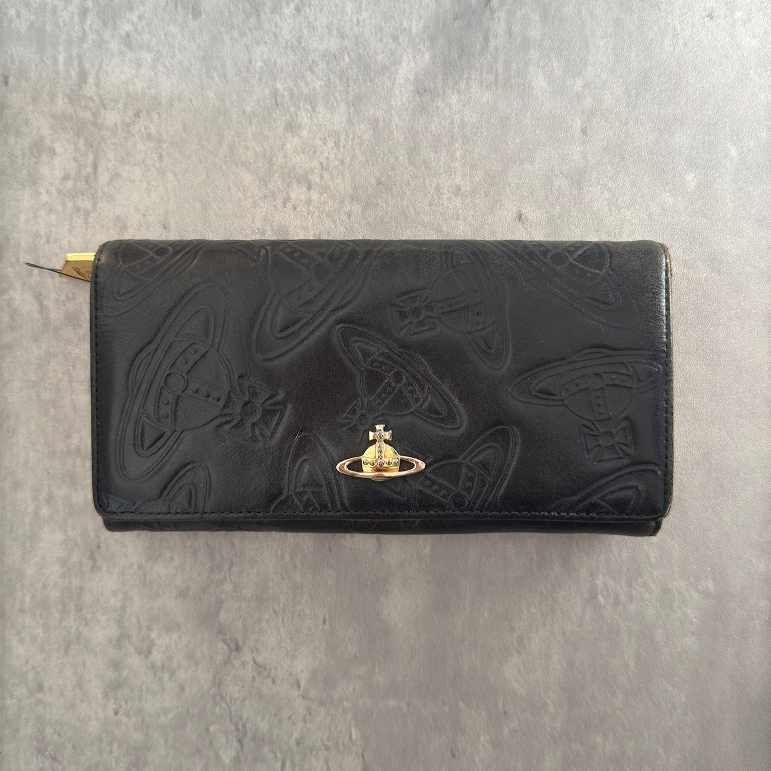 Vivienne Westwood Dancing Orb long wallet in black with iconic orb embossing, featuring a structured interior and clip closure, represents bold, punk-inspired luxury.