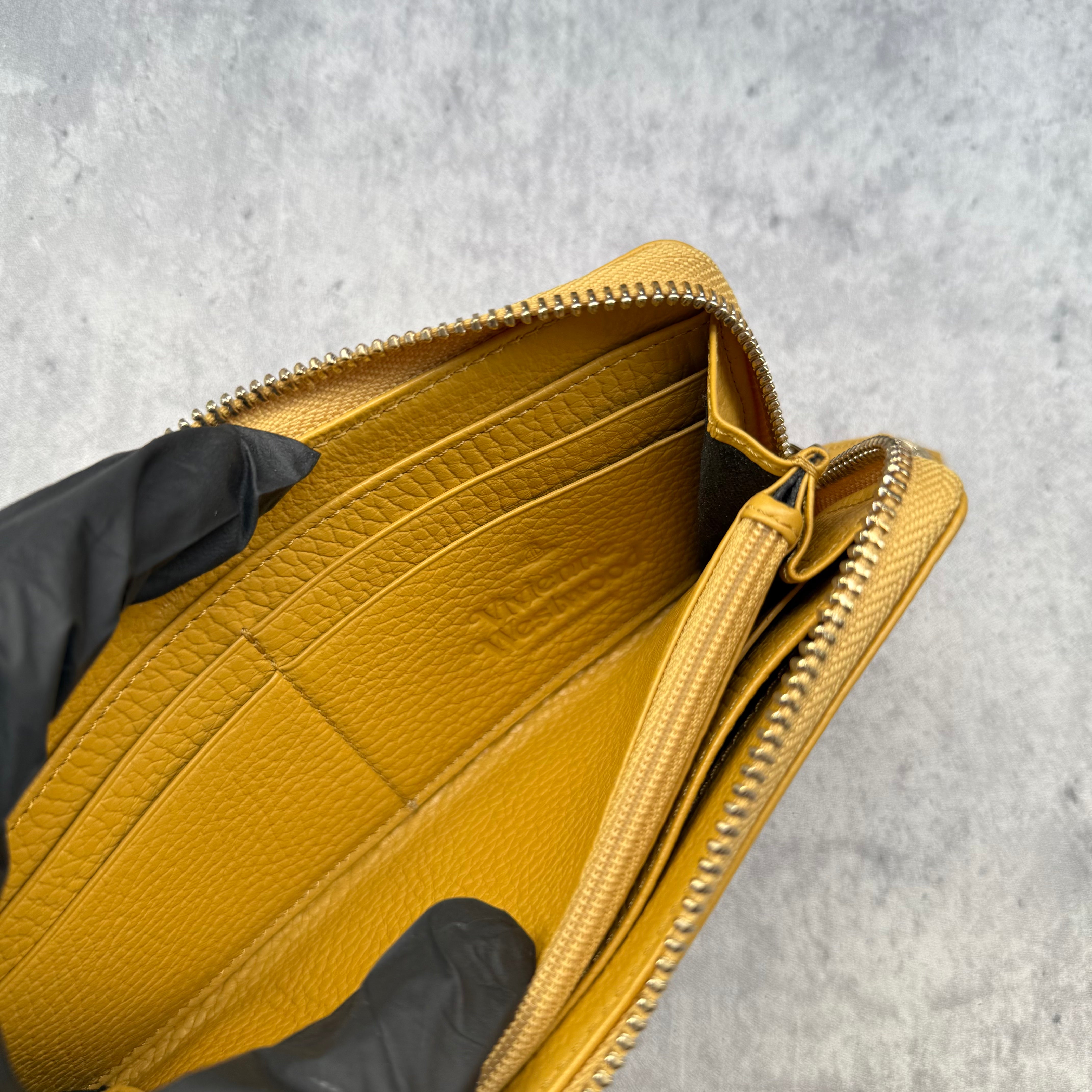 Vivienne Westwood Signature Orb Long Wallet in Yellow grained leather with silver-tone Orb hardware and zip-around design.