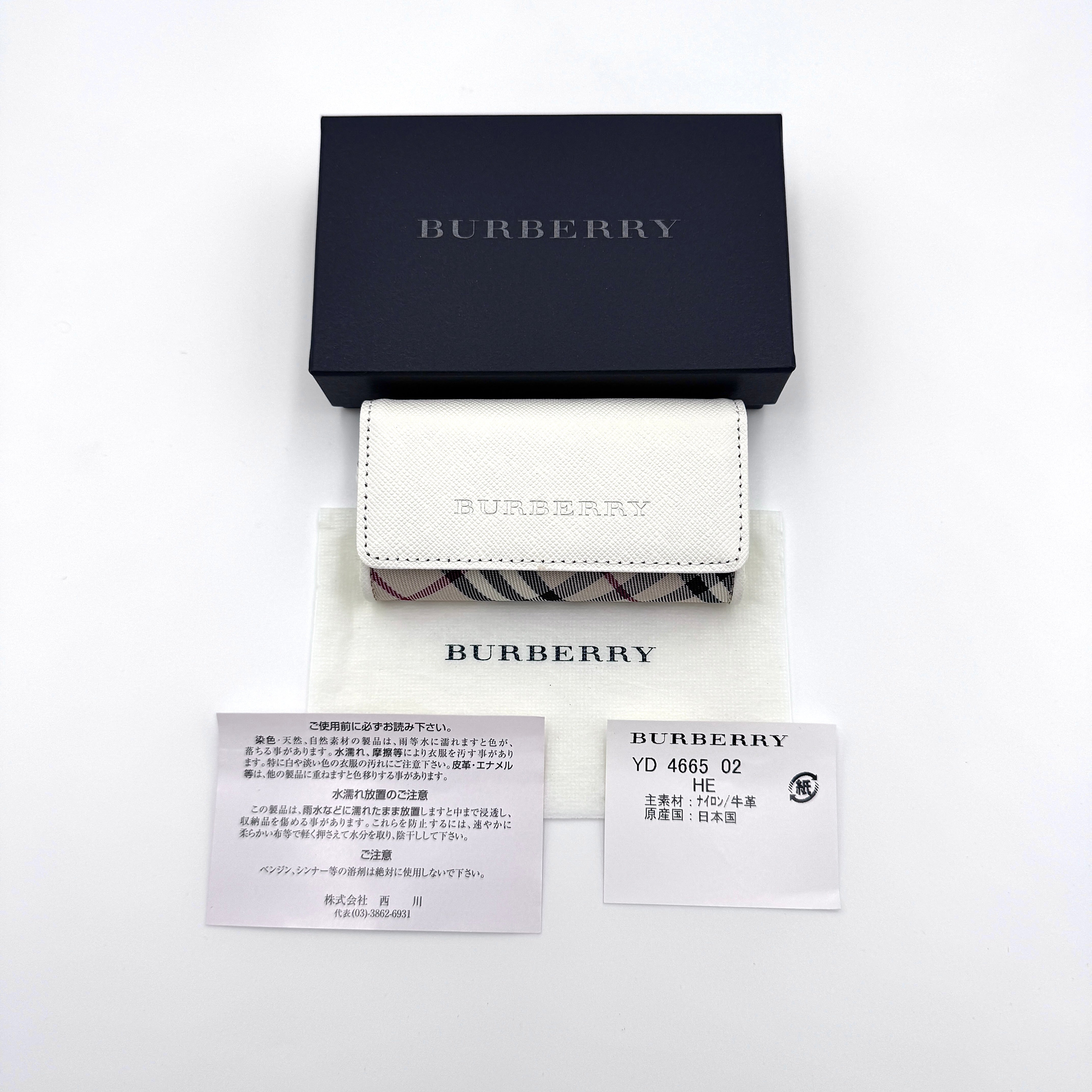 Burberry Nova Check key case in beige featuring iconic check pattern, flap closure, and key hooks, shown with box and dust bag