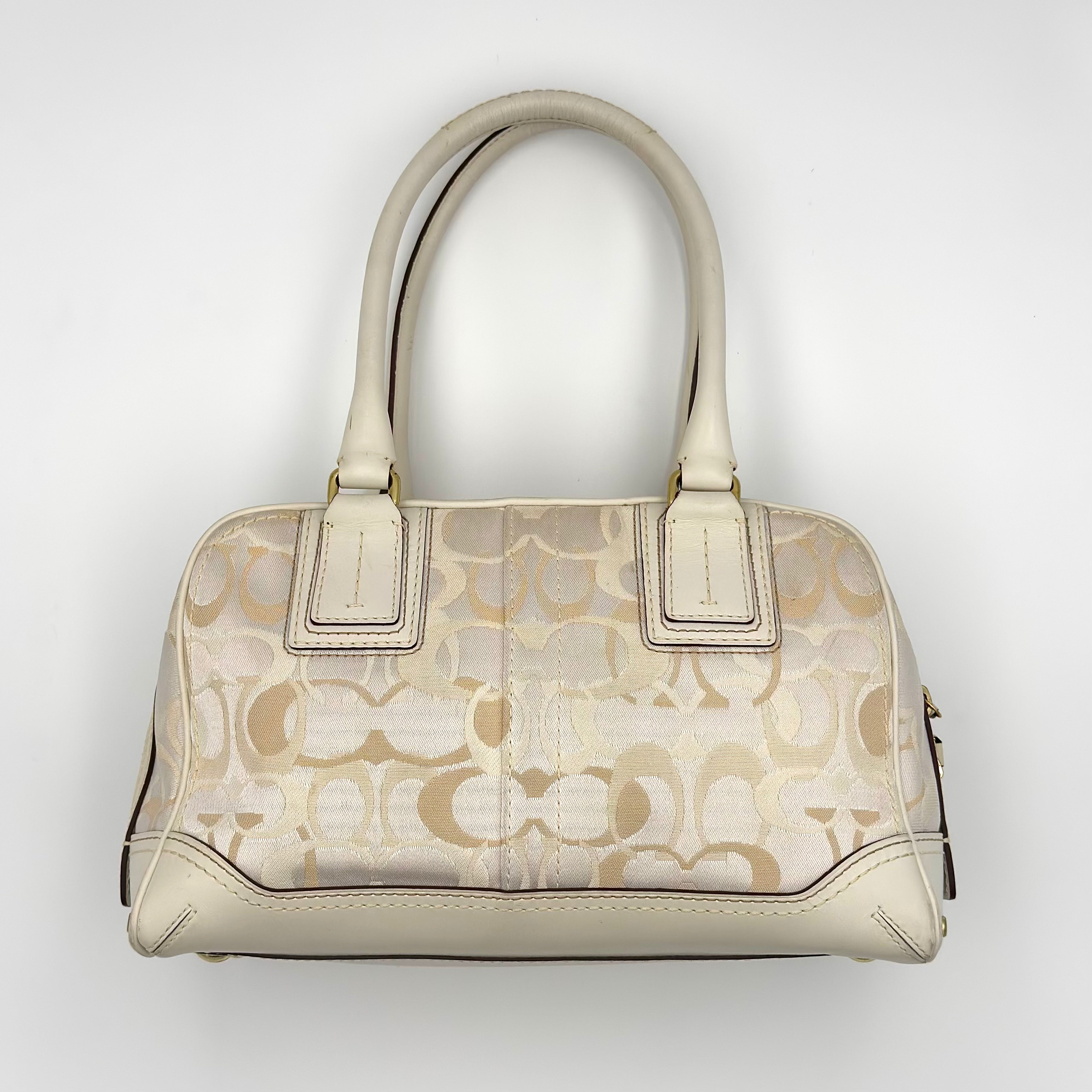 Discover the Coach Signature Canvas Satchel Handbag in white and beige monogram canvas with leather trim, available at Elevated Studios. Free delivery across Malaysia and worldwide shipping available.