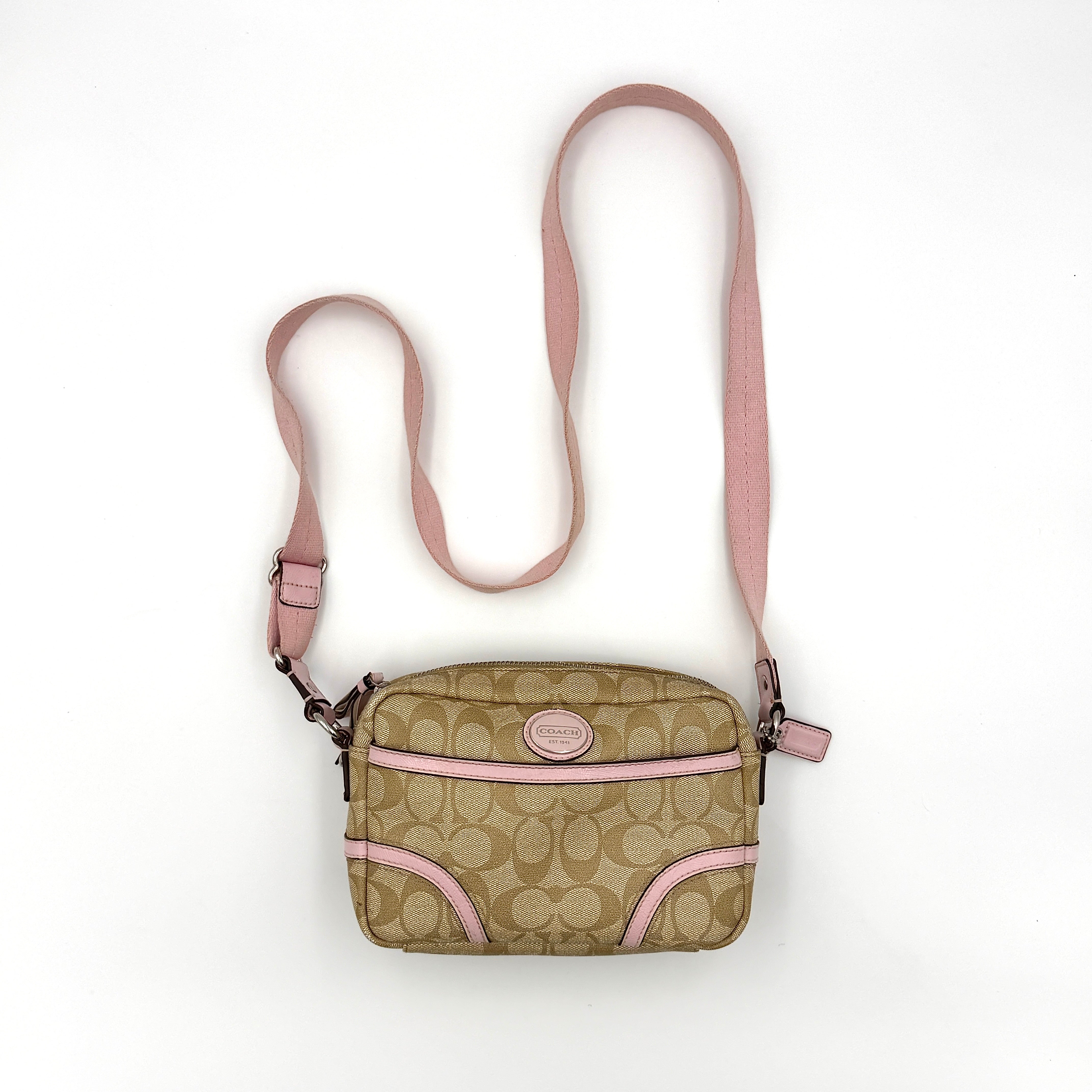 Coach signature canvas crossbody bag in beige with pink leather trim and zip-top closure.