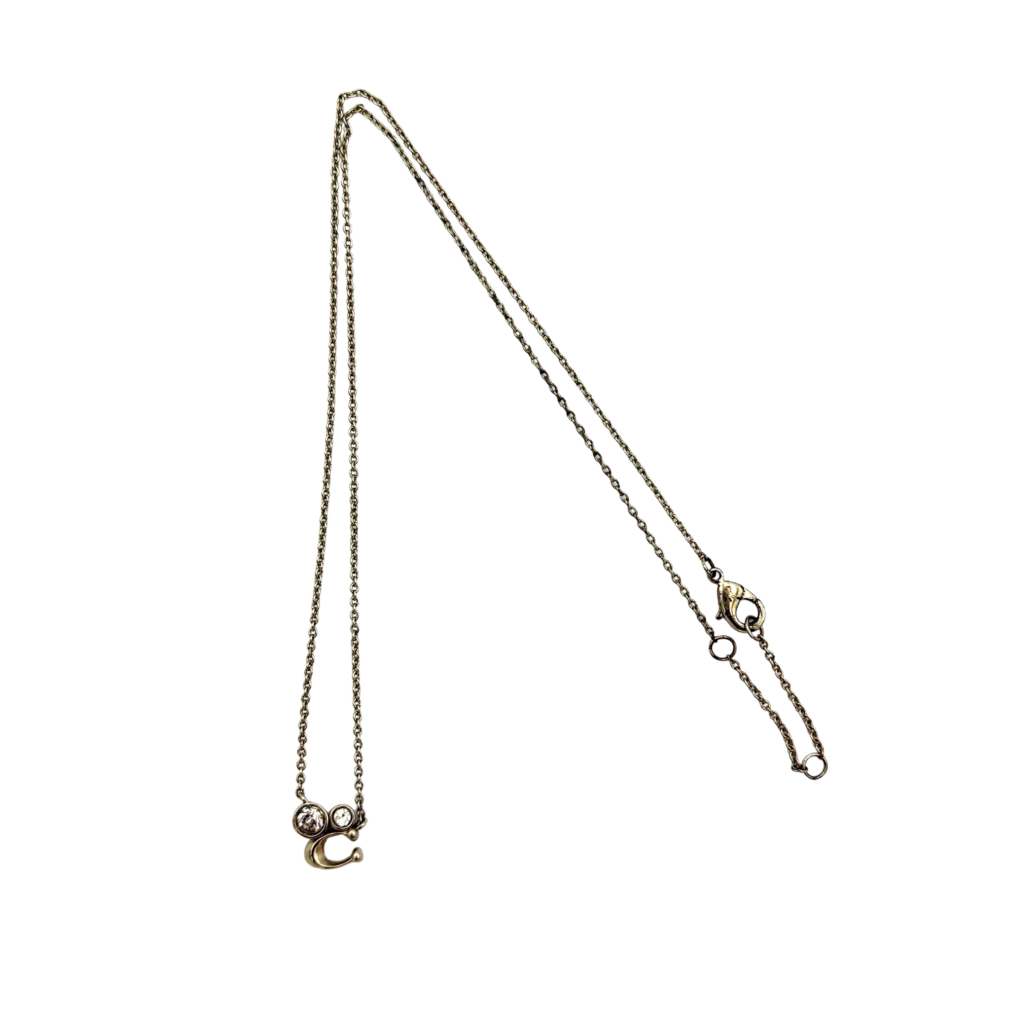 Coach signature crystal cluster necklace in gold tone featuring a small crystal cluster charm and Coach “C” detail on a fine chain with lobster clasp closure.