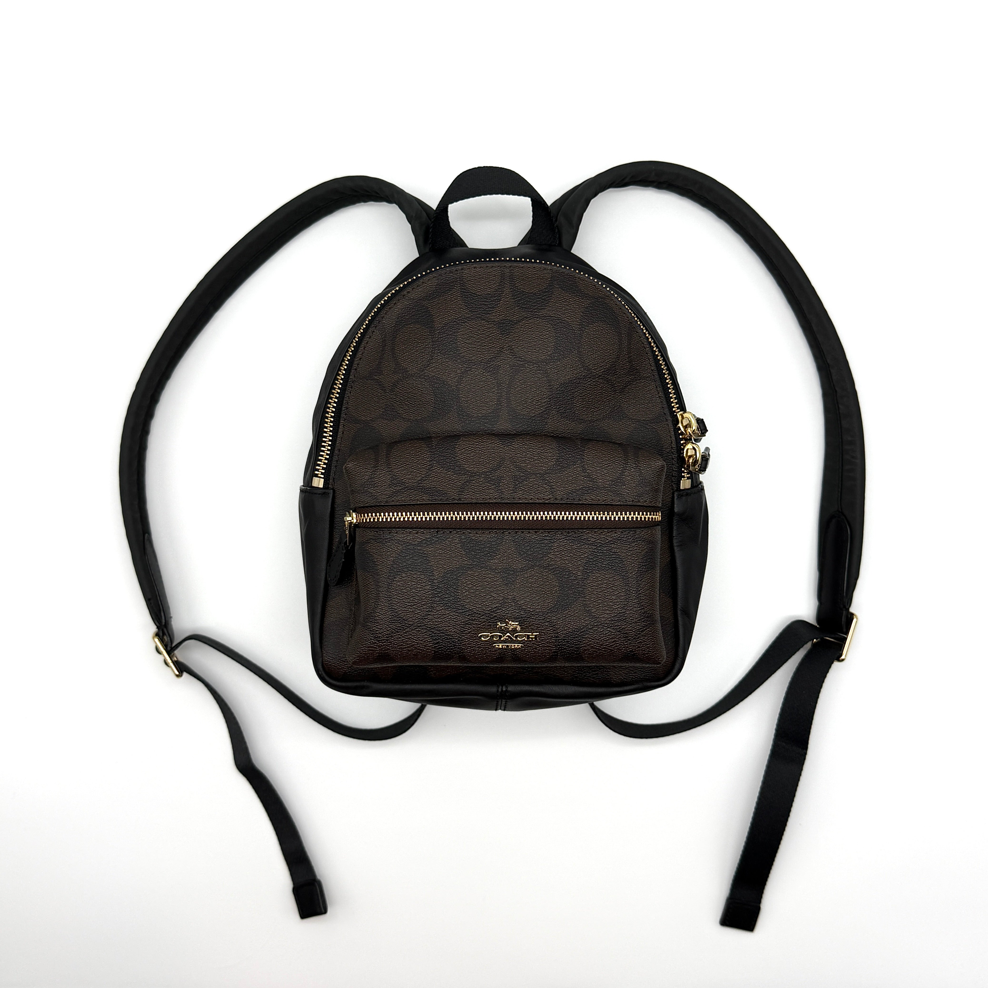 Coach Signature Mini Charlie Backpack in brown coated canvas with leather trim and gold-tone hardware.