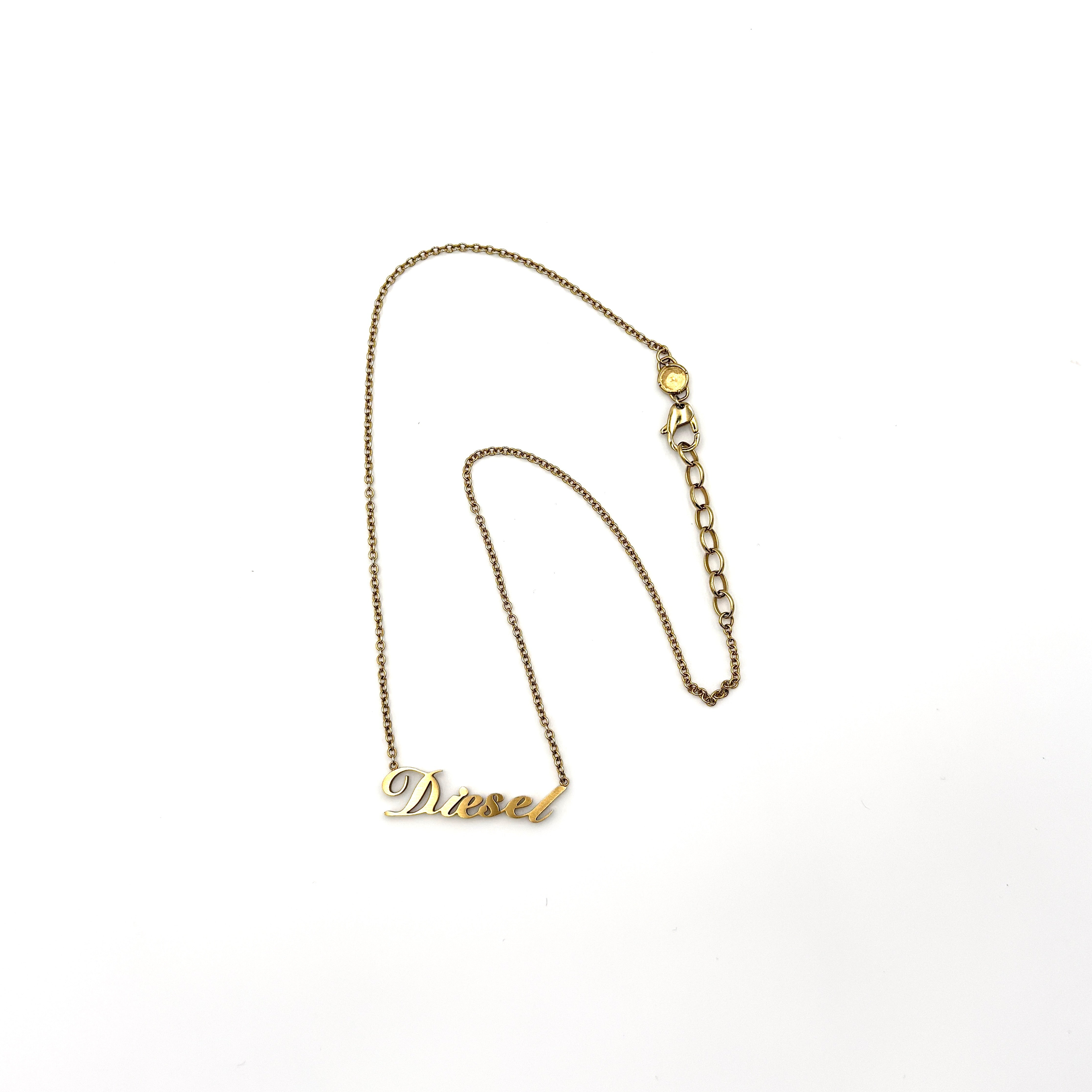 Diesel DX1372 gold stainless steel necklace with script pendant and adjustable chain.