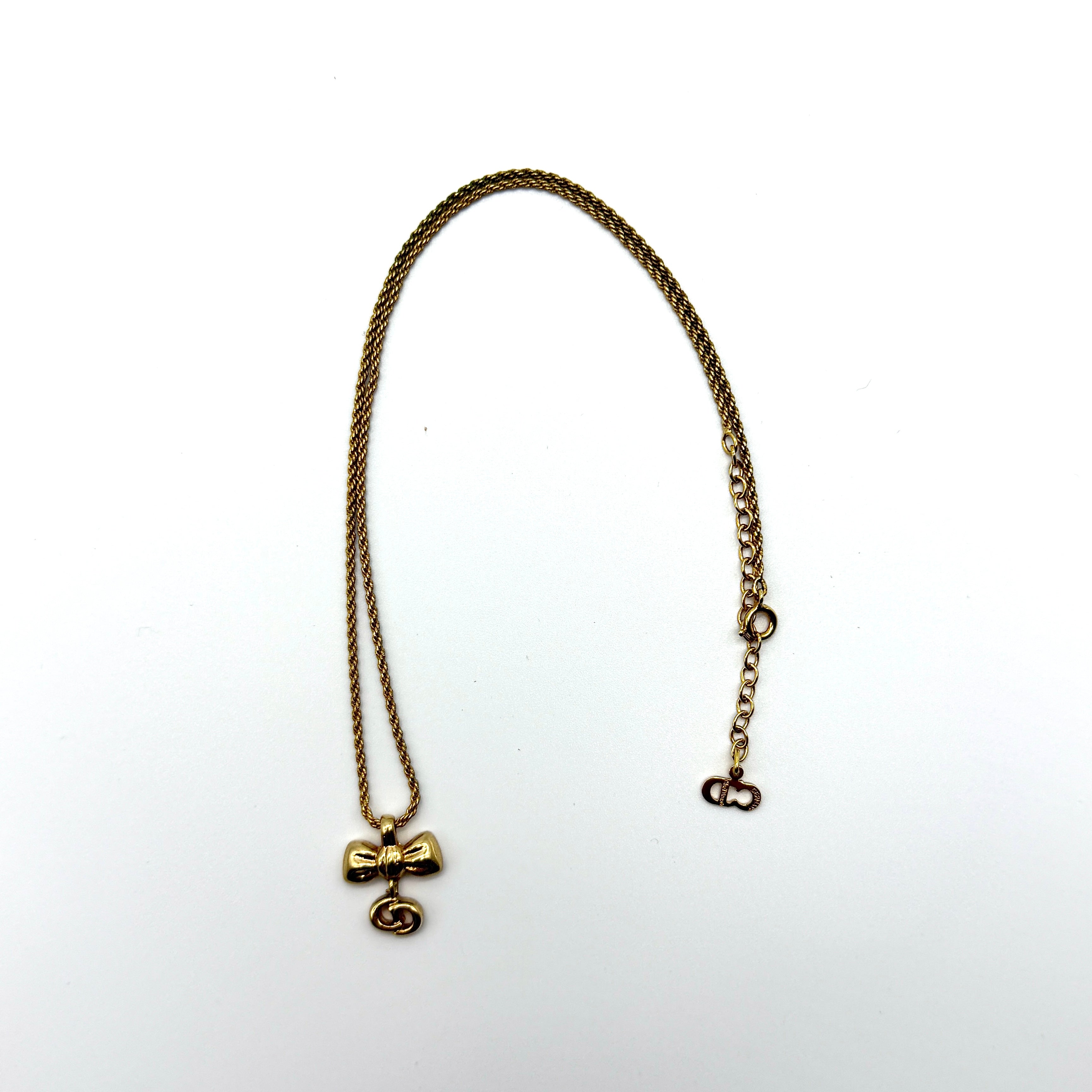 Dior Ribbon Preloved Luxury Necklace in gold-tone metal with CD logo charm and bow pendant.