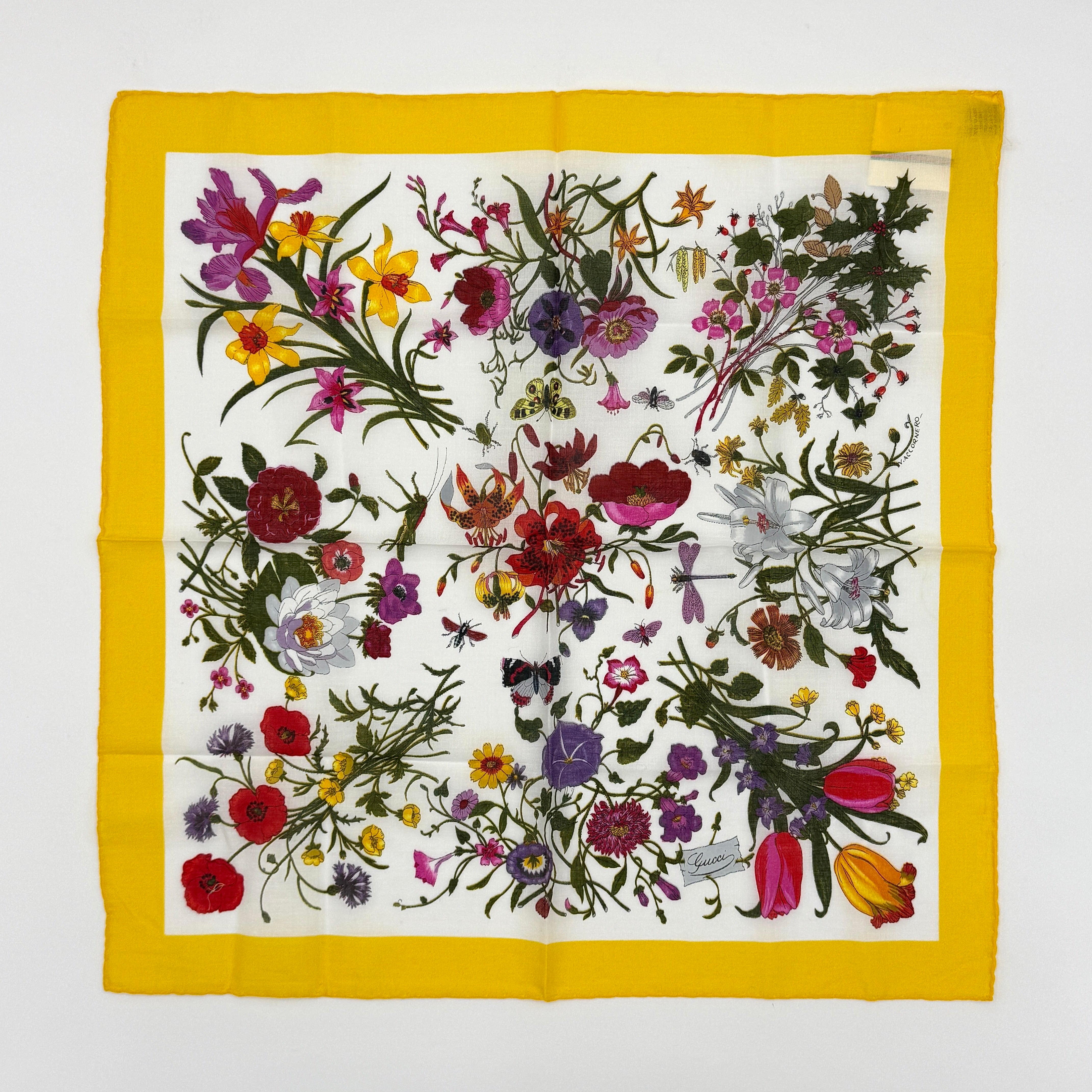 Gucci Flora silk scarf featuring a bright botanical print in yellow and multicolor, elegant floral design, and graceful silk drape