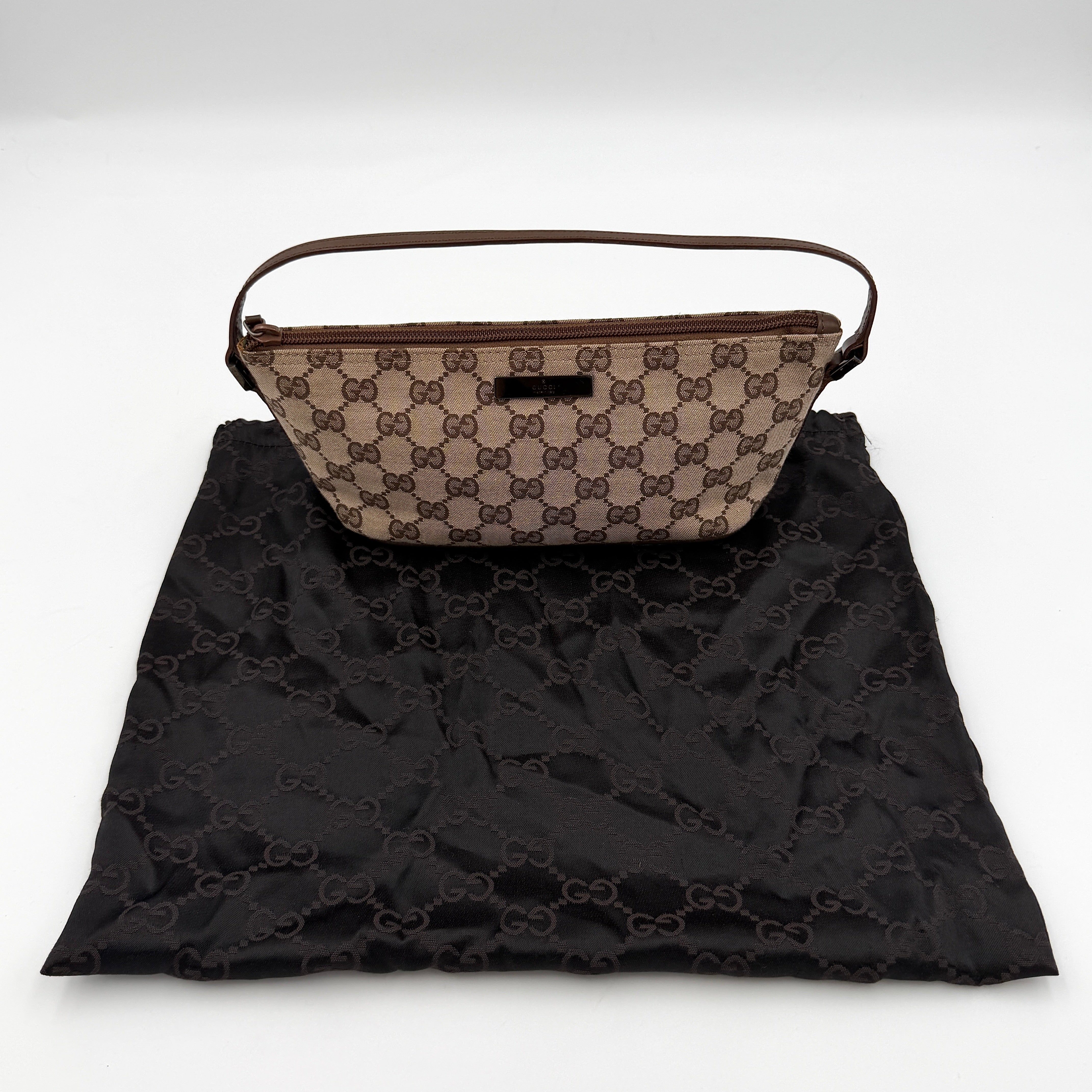 Gucci GG monogram pochette boat shoulder bag in beige canvas with brown leather trim and silver-tone logo plaque.