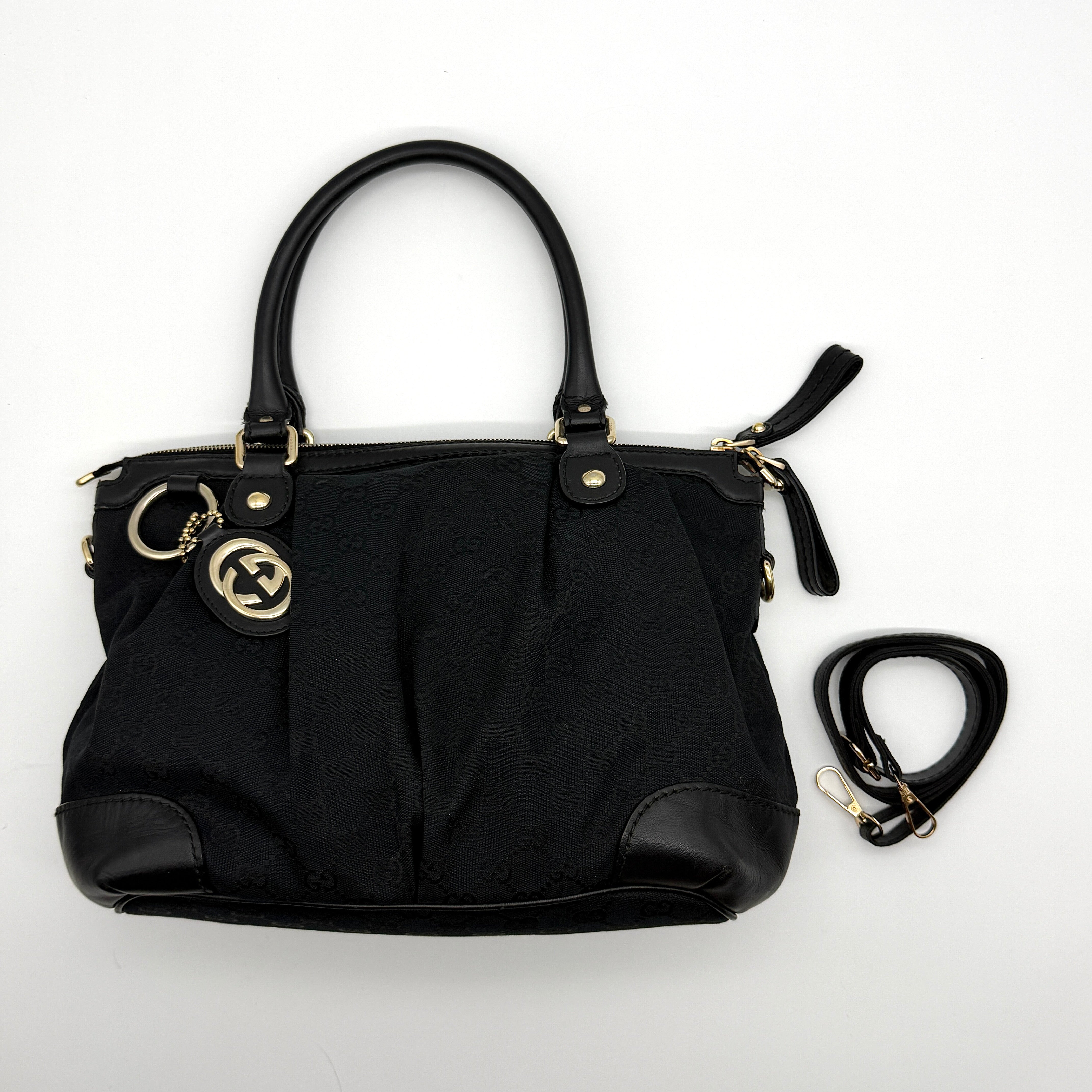 Gucci GG Monogram Shoulder Bag in black jacquard canvas with leather trim, gold-tone hardware, and detachable strap.