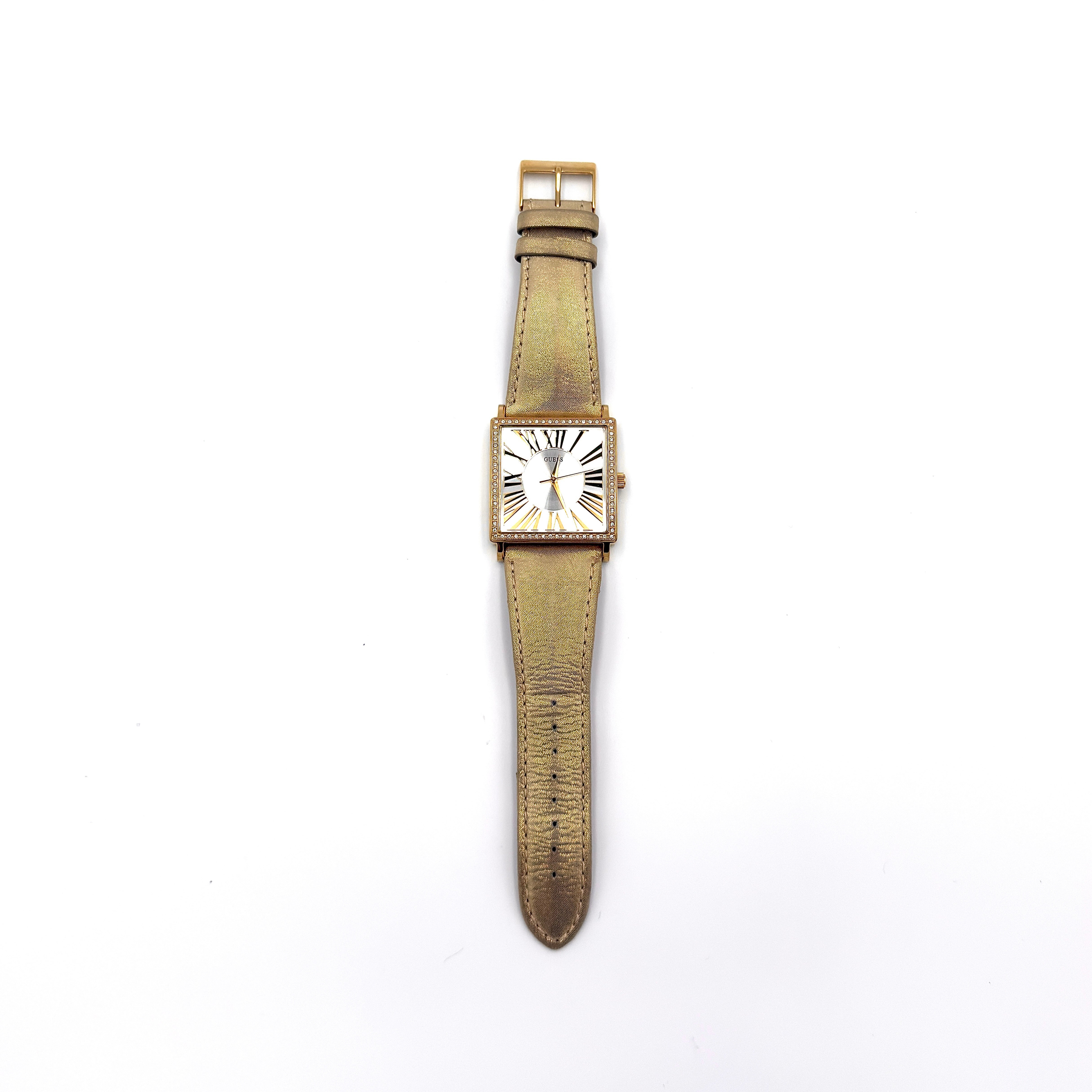 Guess gold square watch with crystal bezel, Roman numeral dial, and gold leather strap.