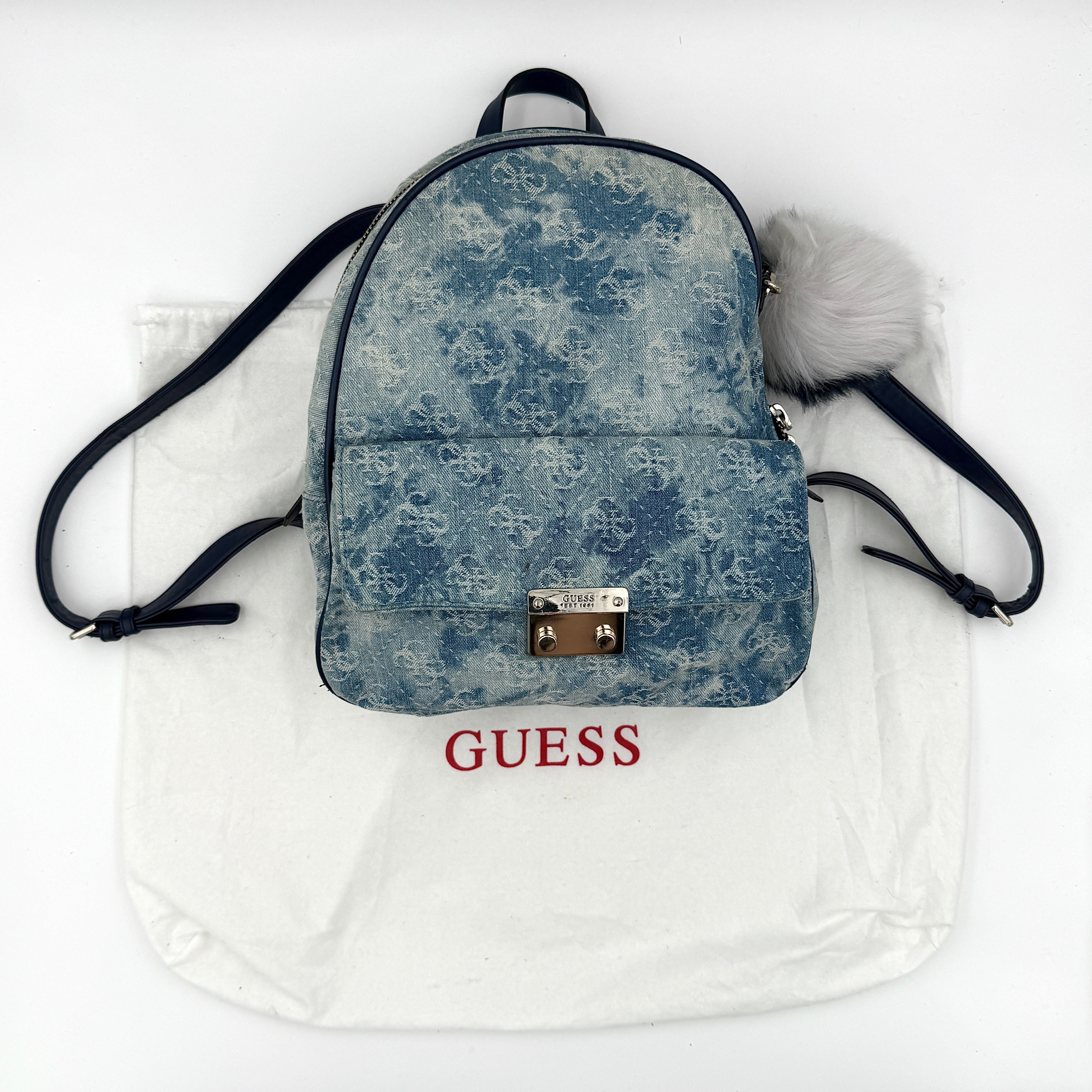 Guess monogram Varsity Pop denim backpack in blue shown from the front with metal logo plaque and adjustable shoulder straps