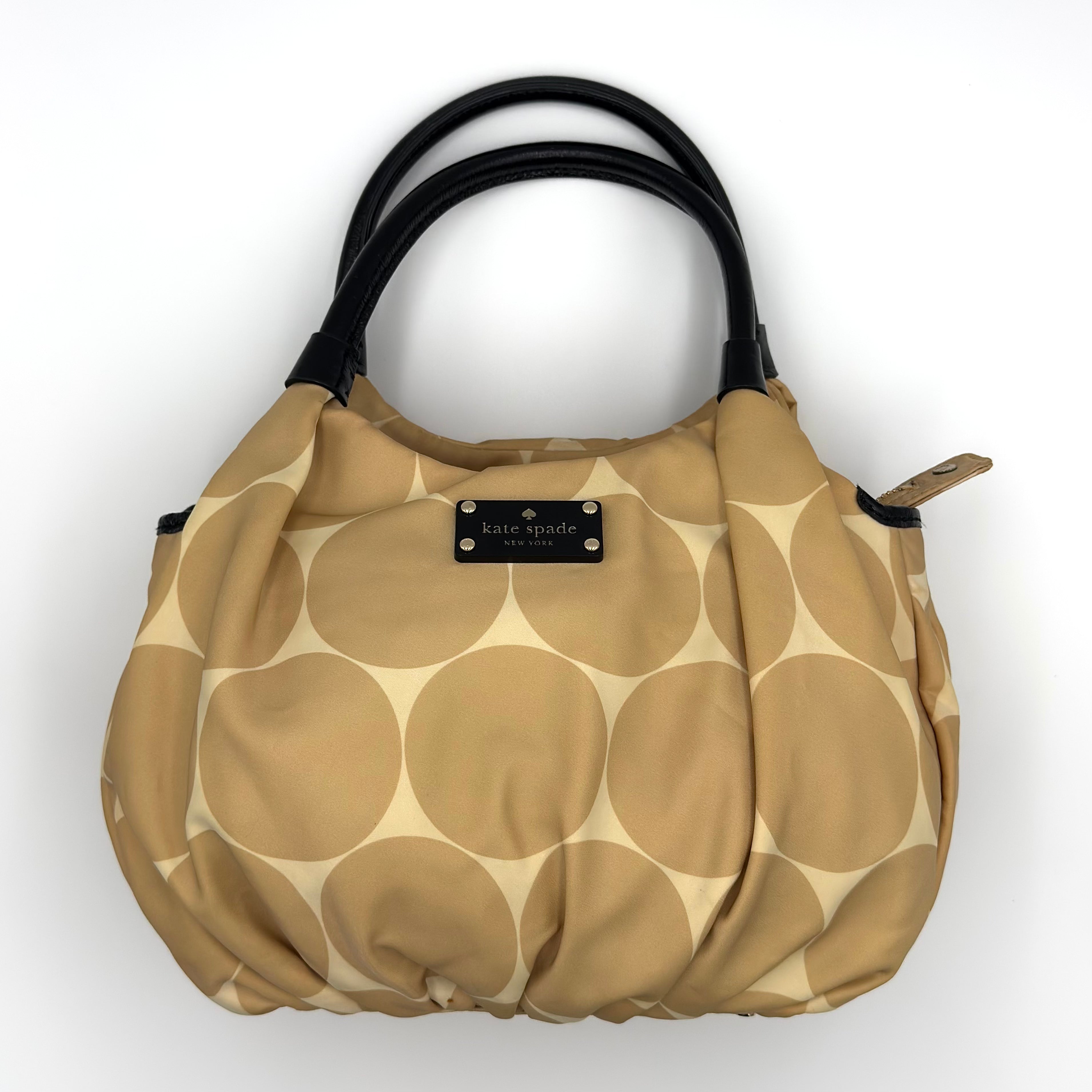Kate Spade New York Deborah Dot Nylon Shoulder Bag in brown/beige oversized dot print with black leather handles, gold-tone hardware, and spacious zippered interior.