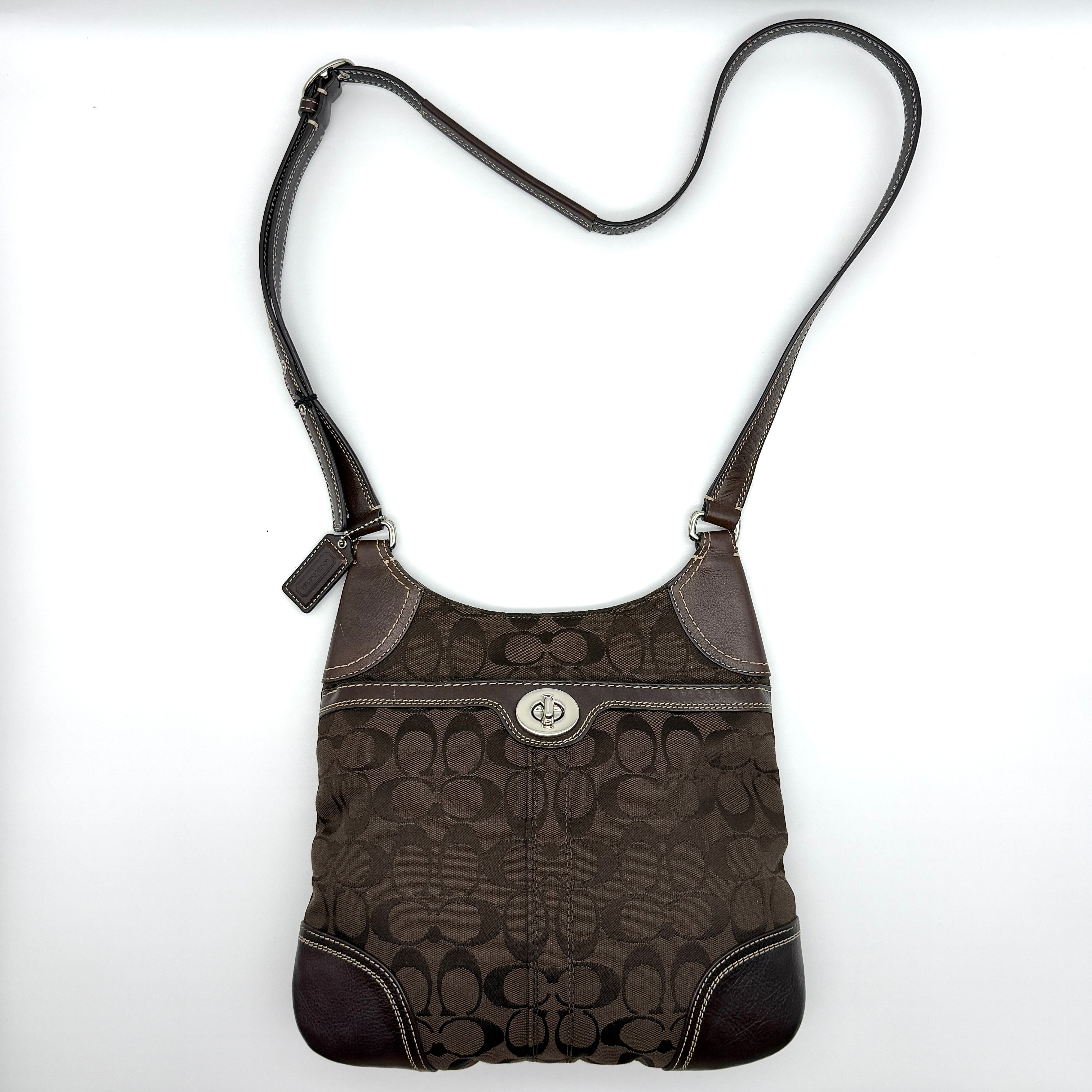 Coach Signature Turnlock Crossbody Bag in brown canvas with silver-tone hardware and adjustable leather strap.