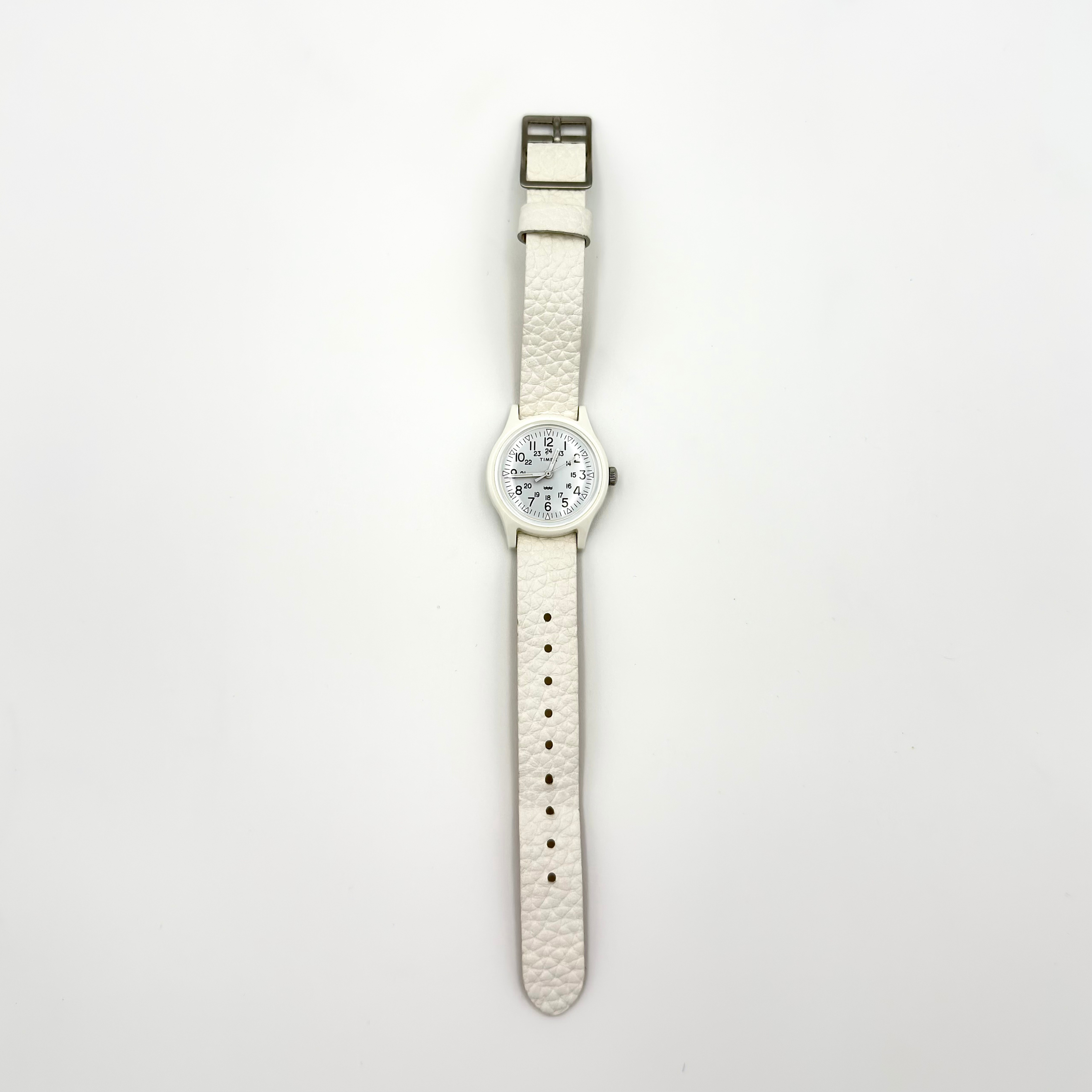 Timex Original Camper 29mm watch with white dial, black numerals, silver-tone hardware, and textured white leather strap.