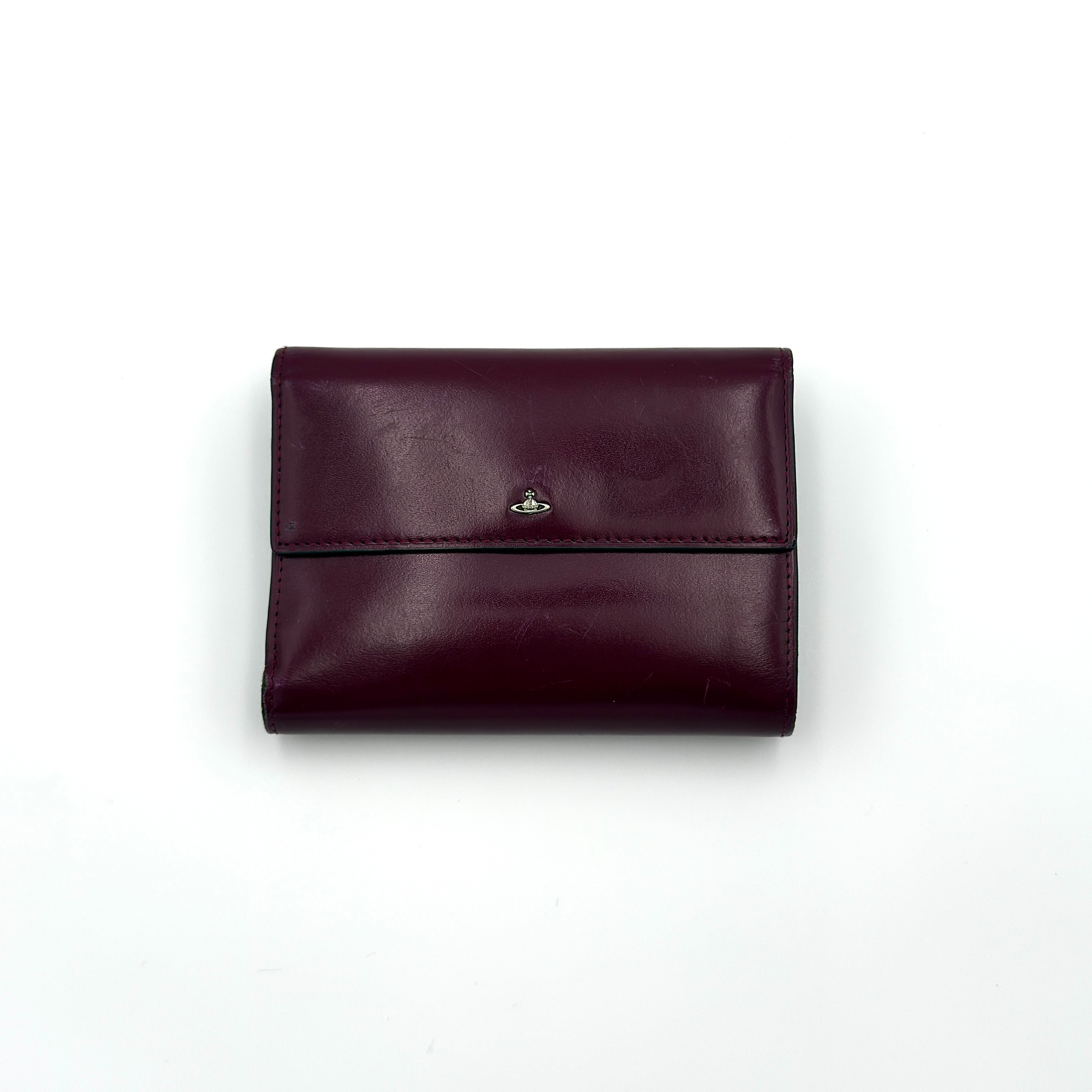Vivienne Westwood burgundy leather trifold wallet with silver-tone Orb emblem and kiss-lock coin pocket.