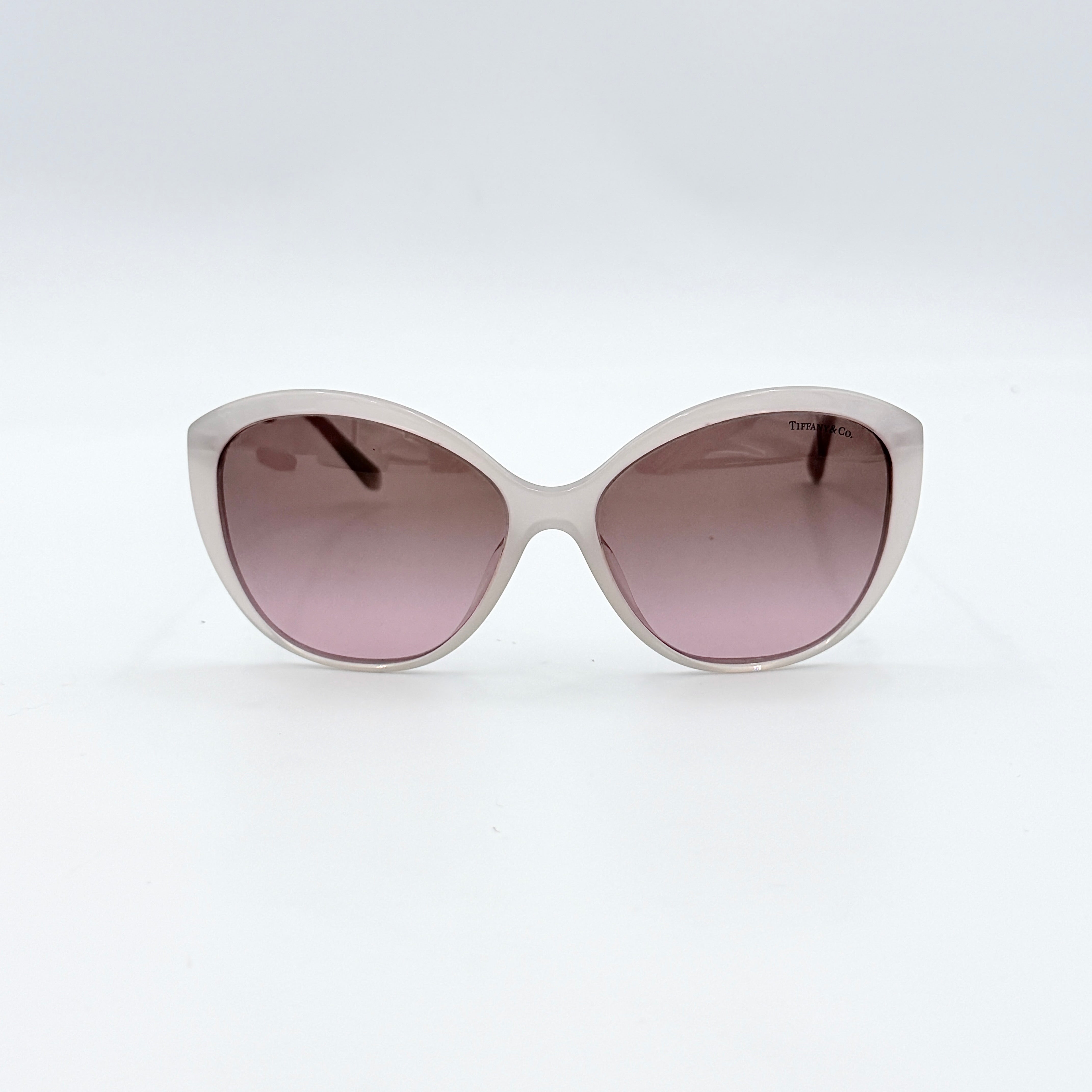 Tiffany & Co. TF4144 sunglasses in pink with gold-tone knot detail arms, shown with signature blue case.