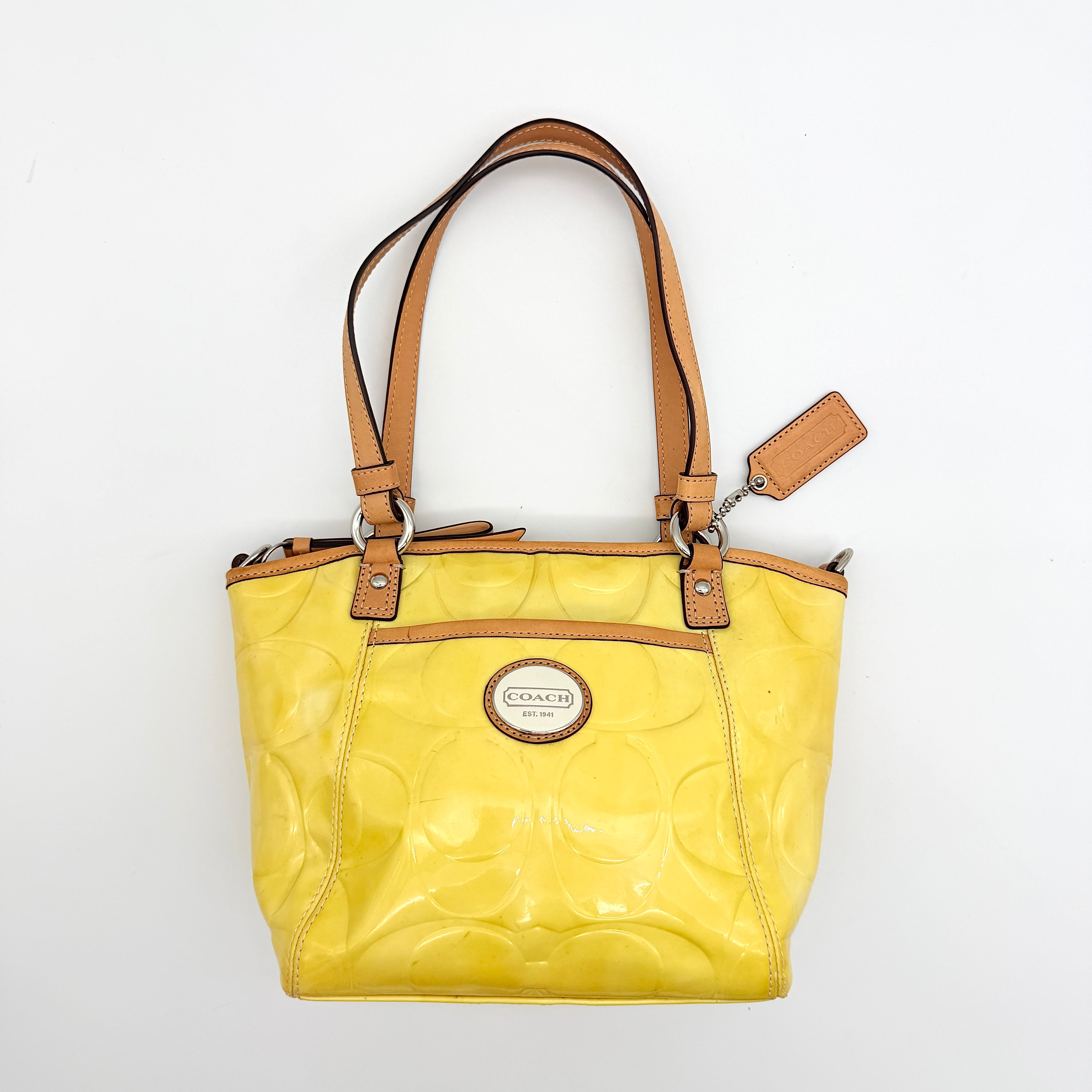 Coach Peyton tote in glossy yellow patent leather with tan handles and detachable strap, shown with blush pink interior.