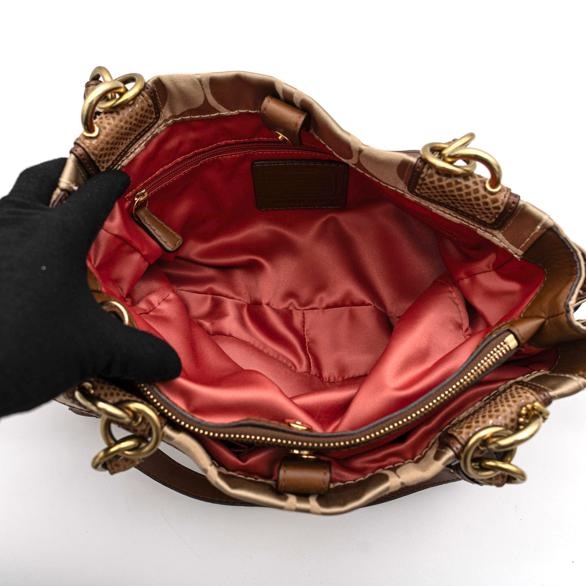 Coach Signature Peyton Shoulder Bag in brown sateen and leather with gold-tone hardware and turnlock pocket, photographed on a white background.