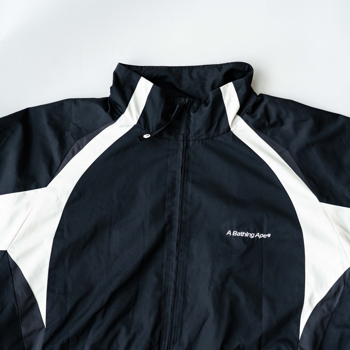 BAPE A Bathing Ape black and white logo track jacket with bold panel detailing, shown laid flat.