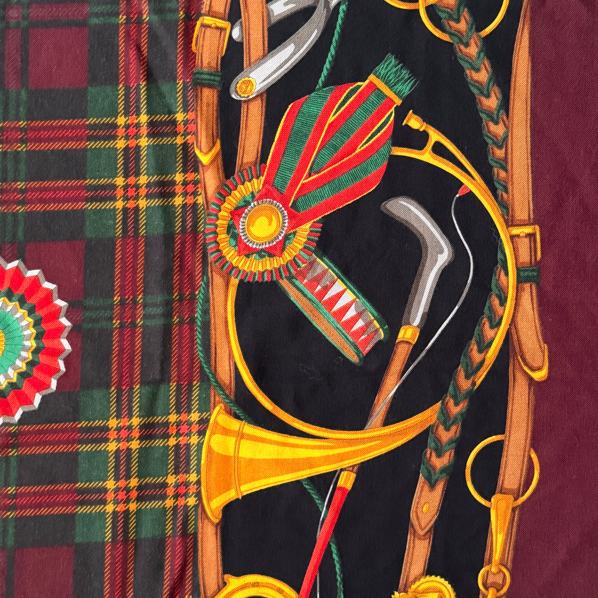 Gucci equestrian tartan shawl scarf in burgundy with heritage motifs and a fringed edge, styled folded.