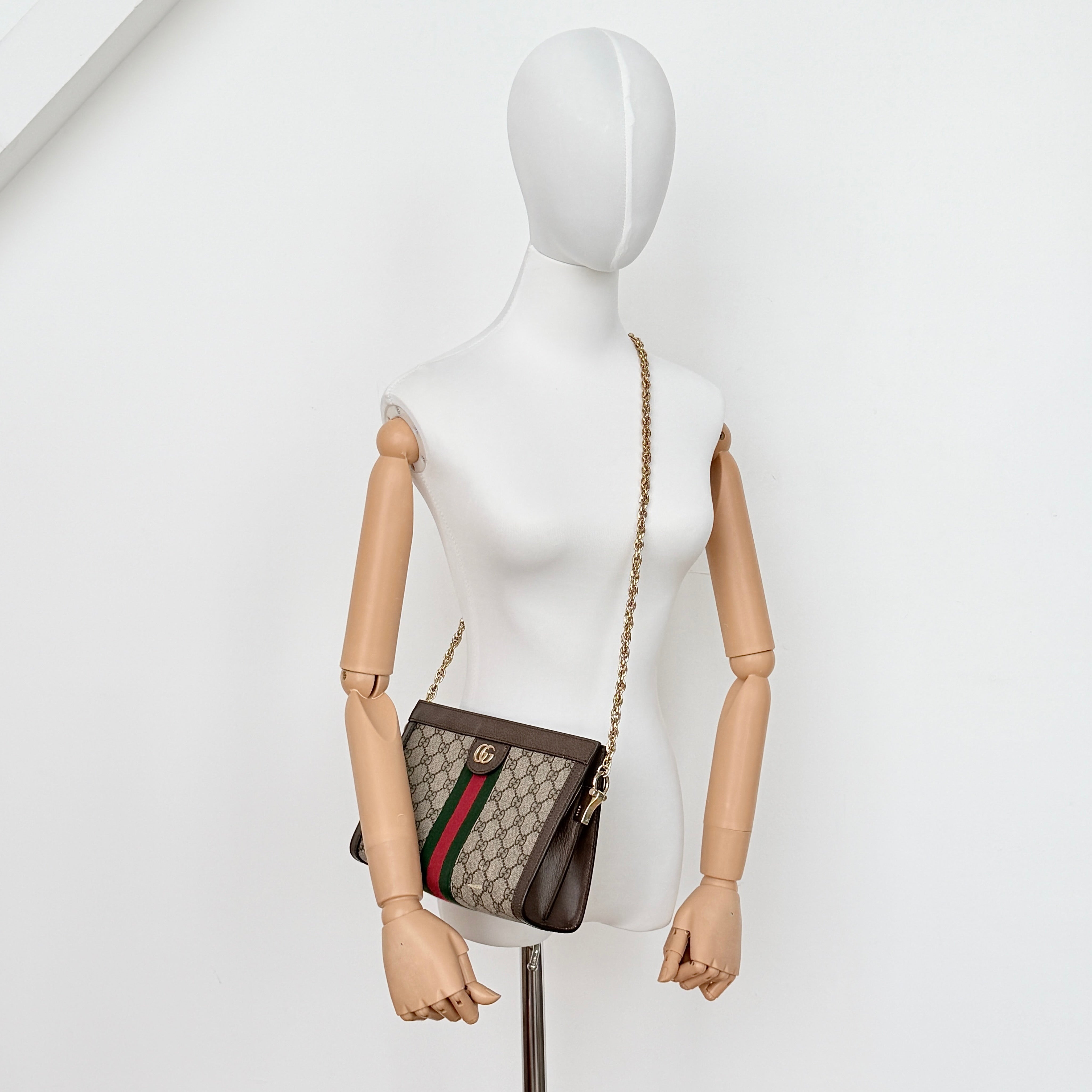 Gucci Ophidia GG Supreme crossbody bag in beige canvas with brown leather trim, signature web stripe, and gold chain strap.