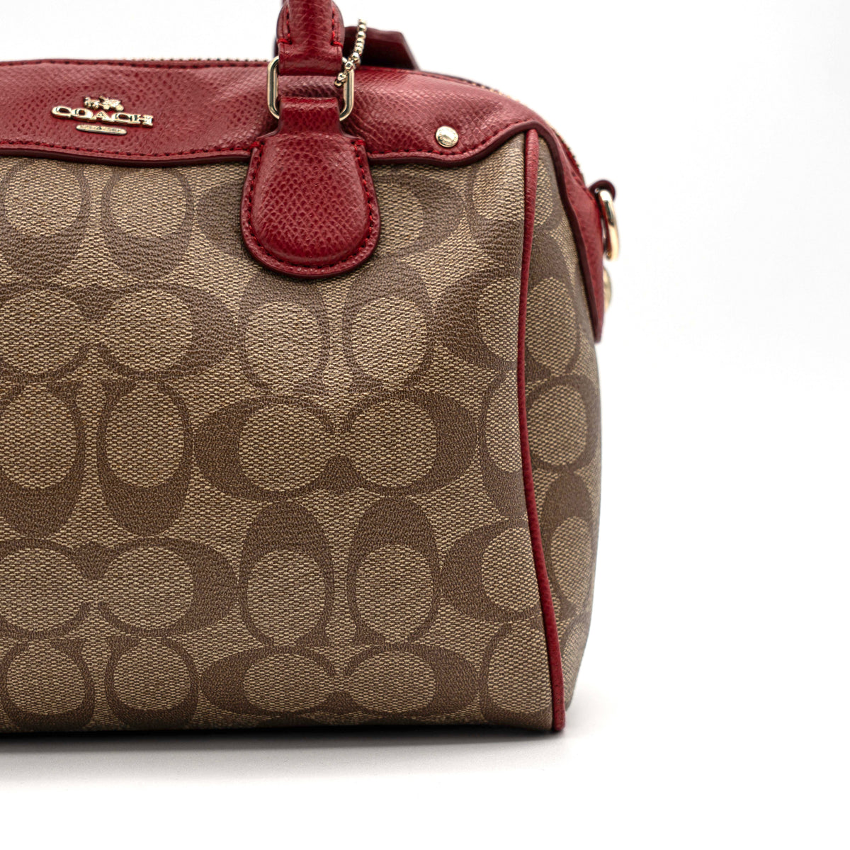 Coach Mini Bennett Boston bag in signature beige canvas with red leather trim, shown with detachable crossbody strap.