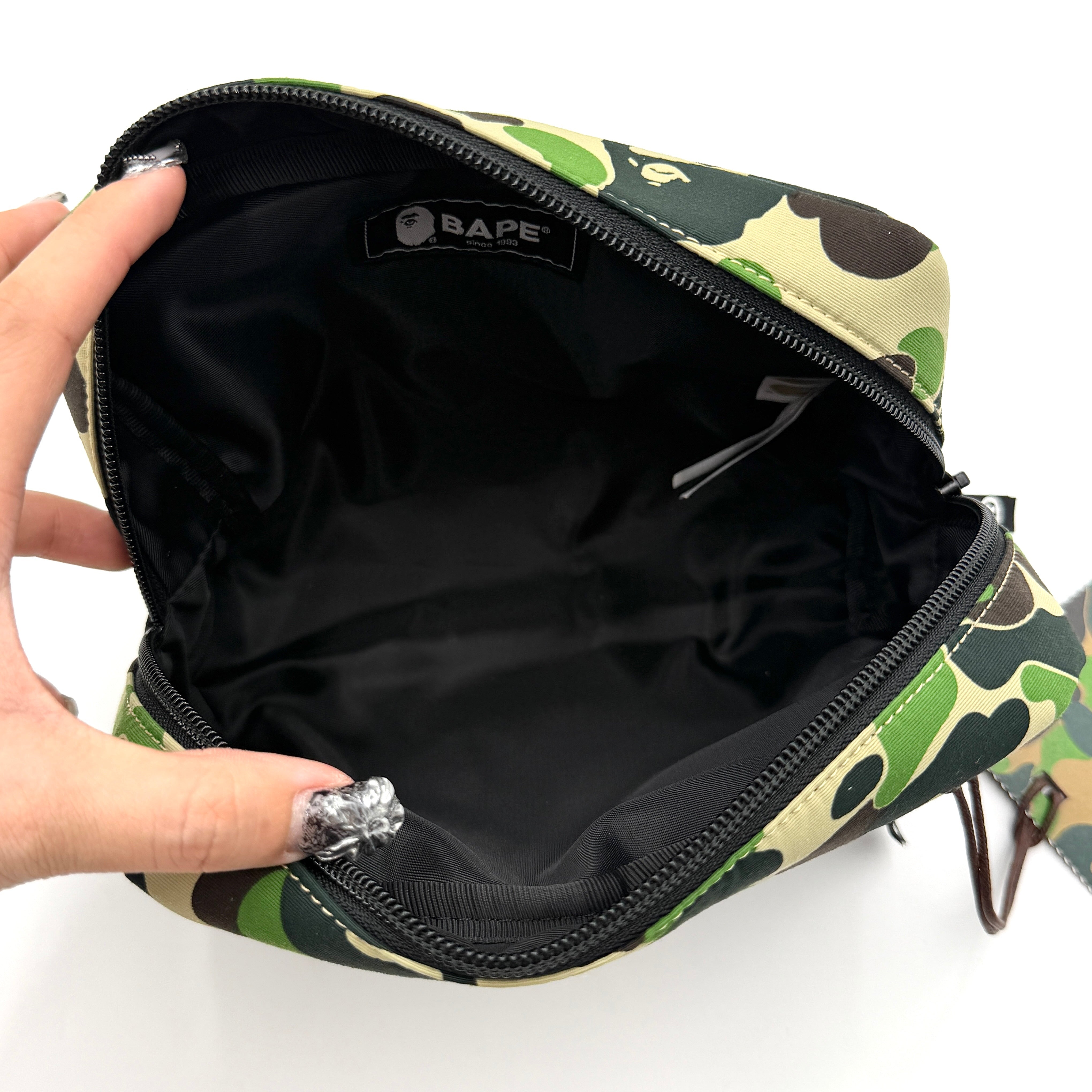 BAPE ABC Camo Pouch in green camouflage with mesh front pocket and embroidered A Bathing Ape logo.