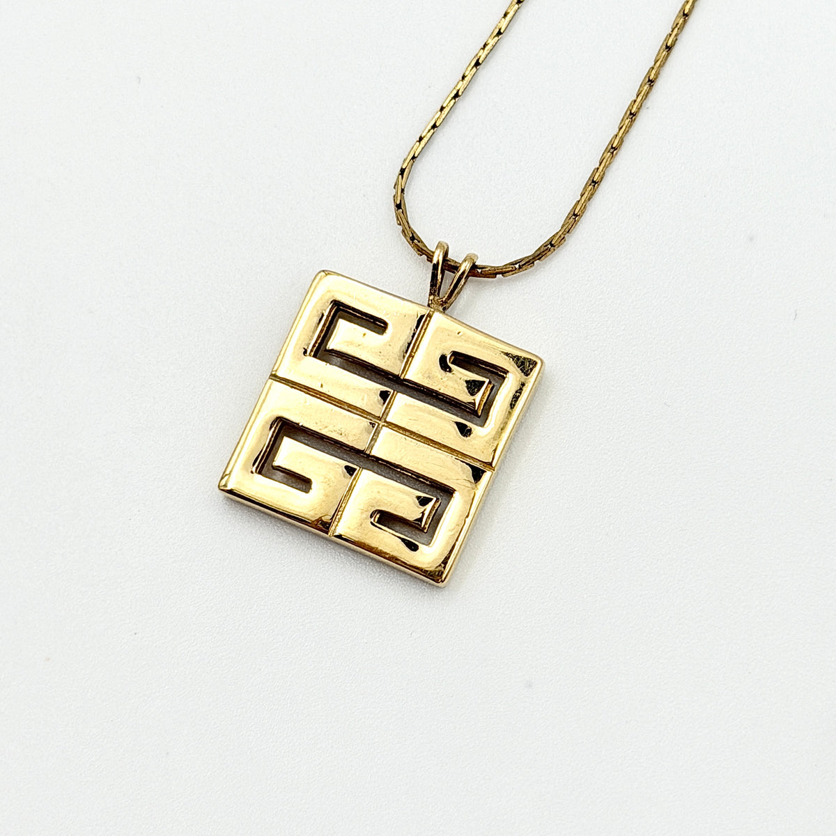 Givenchy 4G Logo Necklace in polished gold-tone metal with a geometric pendant on a fine chain.